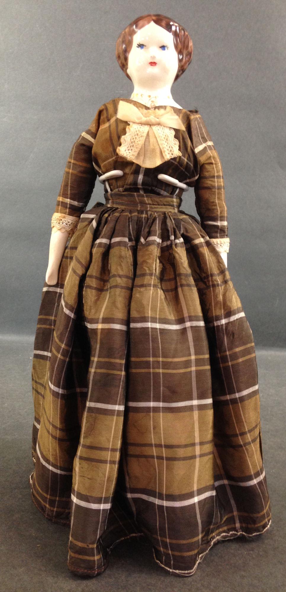 13" RUTH GIBBS CHINA HEAD LADY. MOLDED AND PAINTED: 13" RUTH GIBBS CHINA HEAD LADY. MOLDED AND PAINTED HAIR, FACIAL FEATURES AND NECKLACE, ON STITCH JOINTED CLOTH BODY WITH CHINA LOWER ARMS AND LEGS. DRESSED IN ORIGINAL BROWN PLAID GOWN AND UNDERCLOTHI