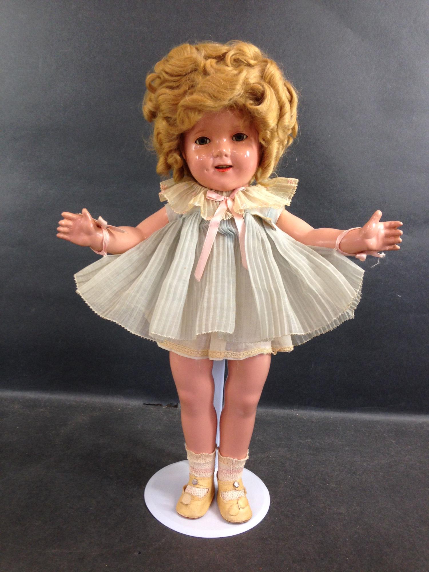 18" IDEAL COMPOSITION SHIRLEY TEMPLE DOLL. MOHAIR WIG: 18" IDEAL COMPOSITION SHIRLEY TEMPLE DOLL. MOHAIR WIG IN ORIGINAL SET, SLEEP EYES, OPEN MOUTH WITH TEETH, ON FIVE PIECE COMPOSITION BODY. DOLL WEARS ORIGINAL TAGGED PLEATED DANCING DRESS IN BLUE FROM