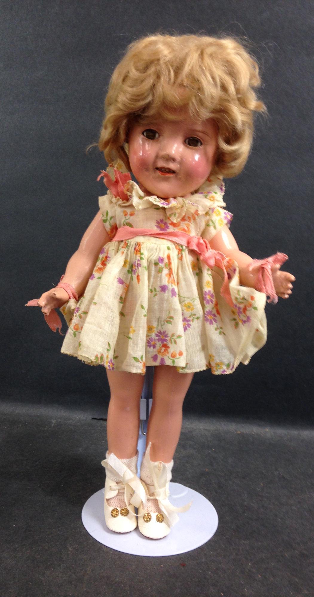 11" IDEAL COMPOSITION SHIRLEY TEMPLE DOLL. ORIGINAL: 11" IDEAL COMPOSITION SHIRLEY TEMPLE DOLL. ORIGINAL MOHAIR WIG, SLEEP EYES, OPEN MOUTH WITH TEETH, ON FIVE PIECE COMPOSITION BODY. DOLL WEARS FLORAL PRINT DANCING DRESS FROM "CURLY TOP", REPLACED UNDE