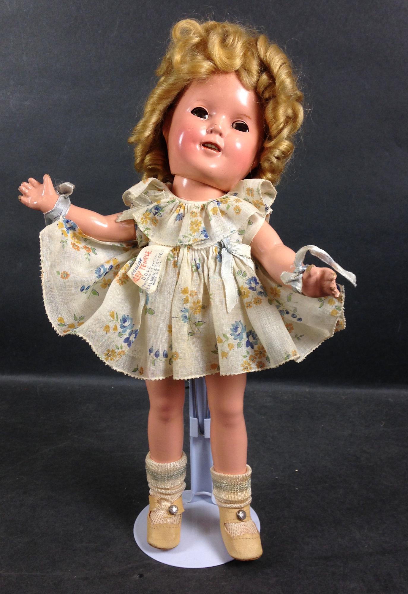 13" IDEAL COMPOSITION SHIRLEY TEMPLE DOLL. MOHAIR WIG,: 13" IDEAL COMPOSITION SHIRLEY TEMPLE DOLL. MOHAIR WIG, SLEEP EYES, OPEN MOUTH WITH TEETH, ON FIVE-PIECE COMPOSITION BODY. DOLL WEARS TAGGED DRESS FROM "CURLY TOP", UNDERCLOTHING, CENTER SNAP SHOES AND