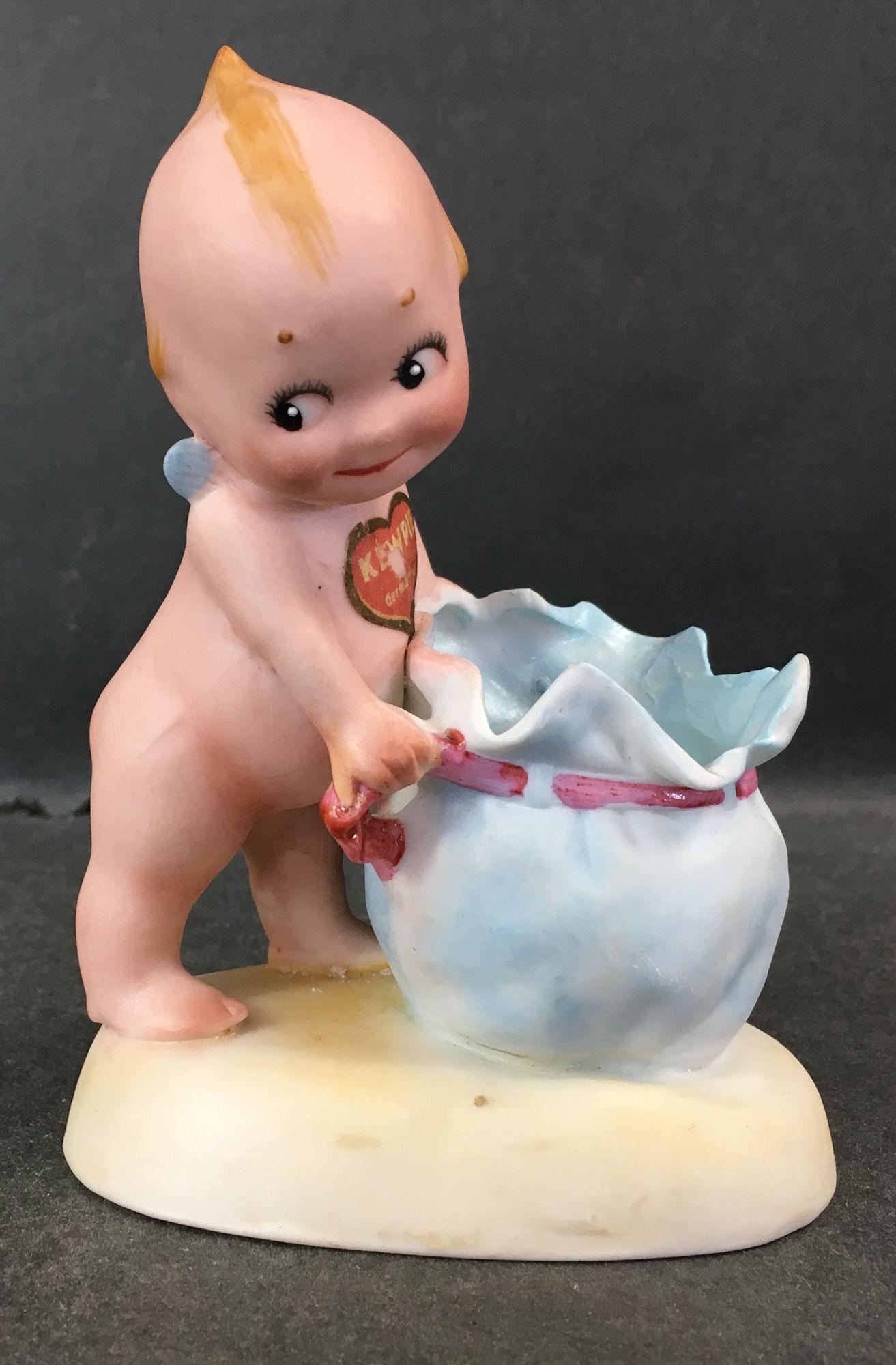 KEWPIE PULLING DRAWSTRING ON BAG. 4½" OVERALL, (1 of 1)
