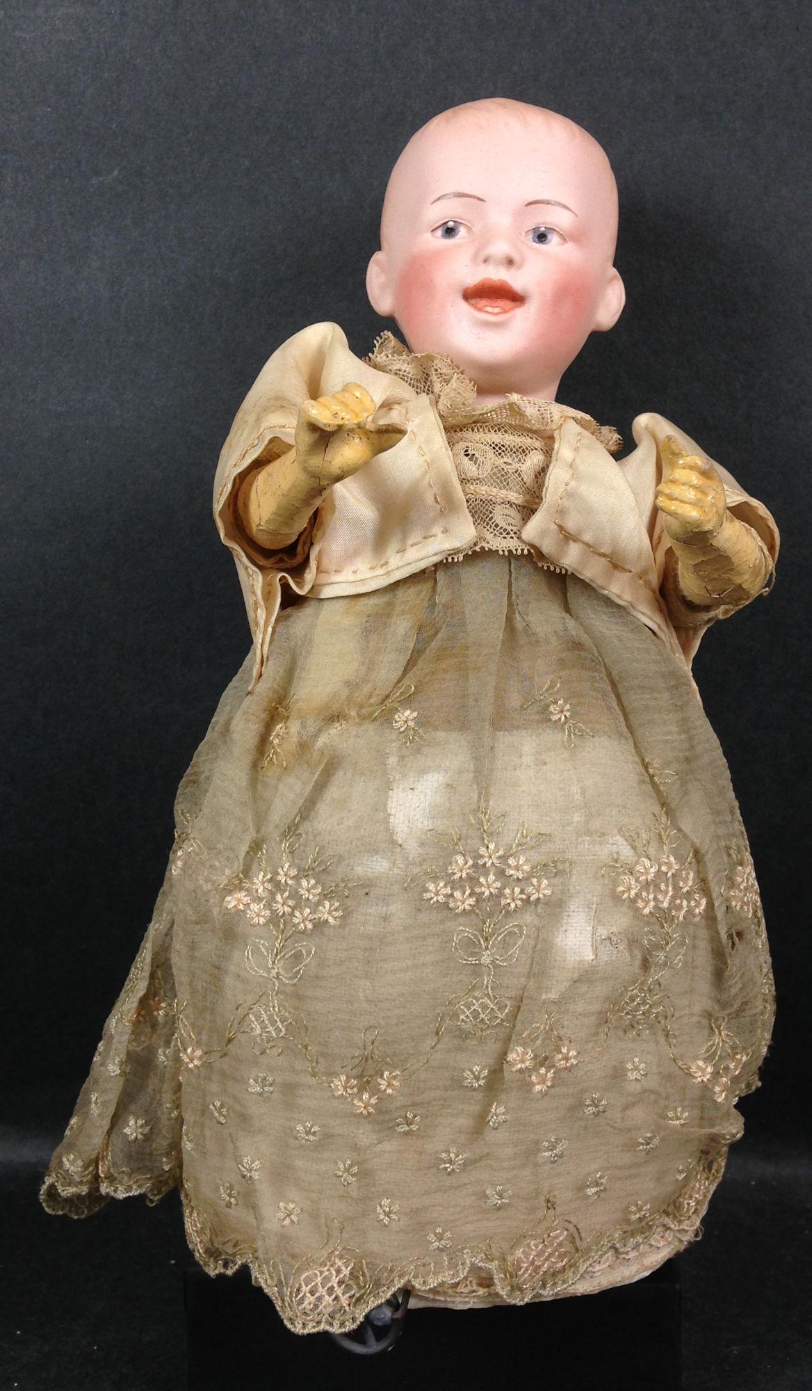 9" GBR. HEUBACH 7604 BISQUE SOCKET HEAD SMILING: 9" GBR. HEUBACH 7604 BISQUE SOCKET HEAD SMILING CHARACTER WIND-UP MECHANICAL DOLL. MOLDED AND PAINTED HAIR, INTAGLIO EYES AND OPEN/CLOSED SMILING MOUTH WITH MOLDED TEETH AND COMPOSITION ARMS. DOLL MOV