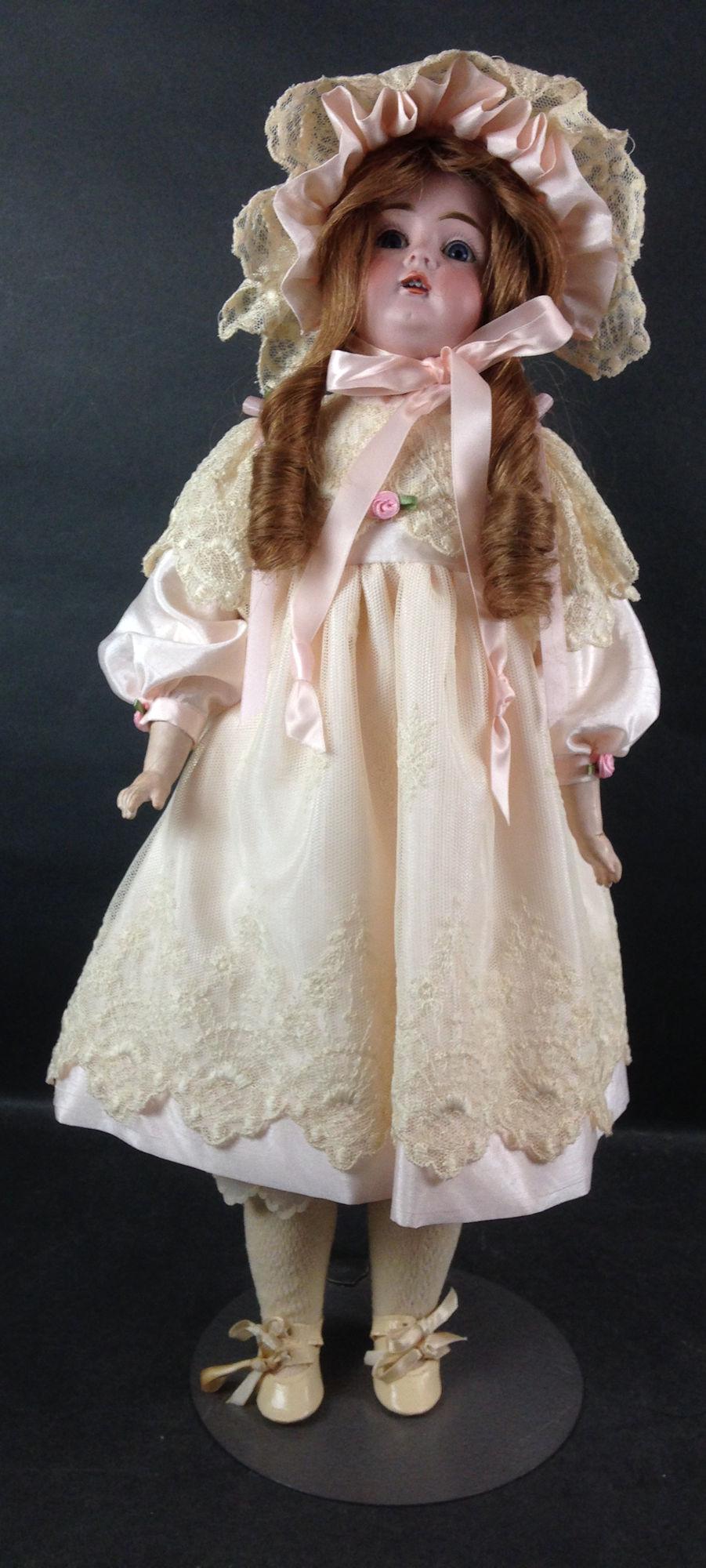 21" KESTNER 129 BISQUE SOCKET HEAD CHILD ON BISQUE: 21" KESTNER 129 BISQUE SOCKET HEAD CHILD ON BISQUE SHOULDERPLATE. CHEVEUX WIG, PLASTER PATE, GLASS SET EYES AND OPEN MOUTH WITH TEETH. RIVET JOINTED KID BODY WITH COMPOSITION LOWER ARMS AND LEGS. DRES