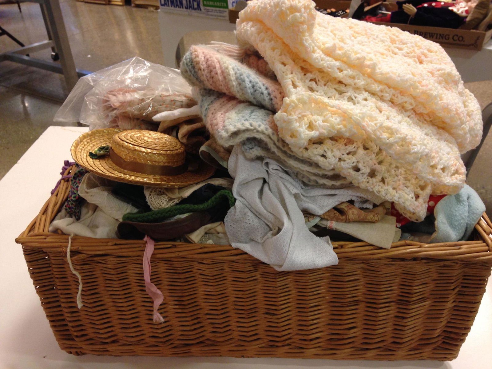 WICKER BASKET FILLED WITH MISCELLANEOUS DOLL CLOTHES (1 of 1)