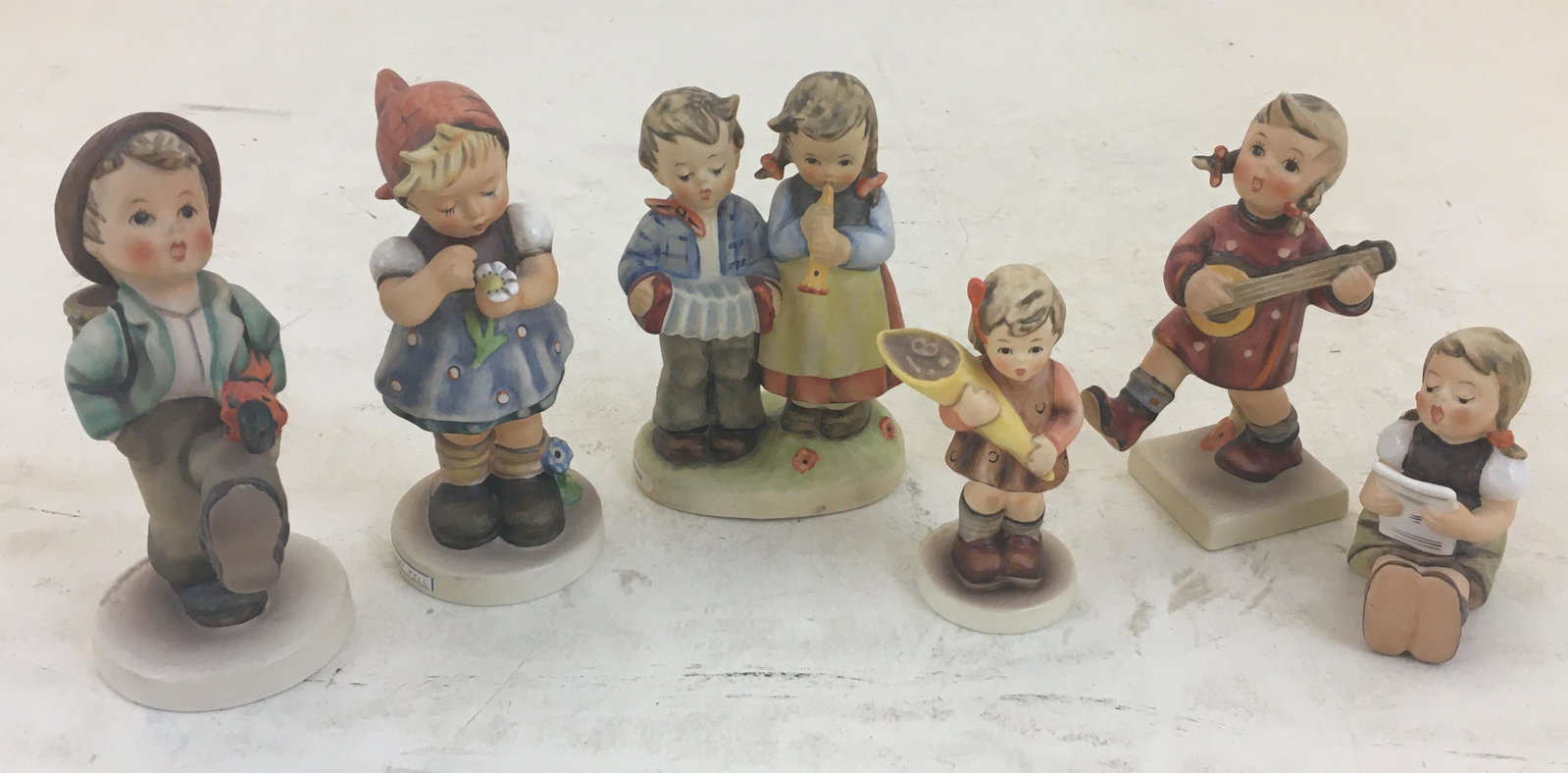 LOT OF 6 HUMMEL FIGURINES INCLUDING "GLOBE TROTTER",: LOT OF 6 HUMMEL FIGURINES INCLUDING "GLOBE TROTTER", 5"H AND "GIRL WITH SHEET MUSIC", 2.5"H