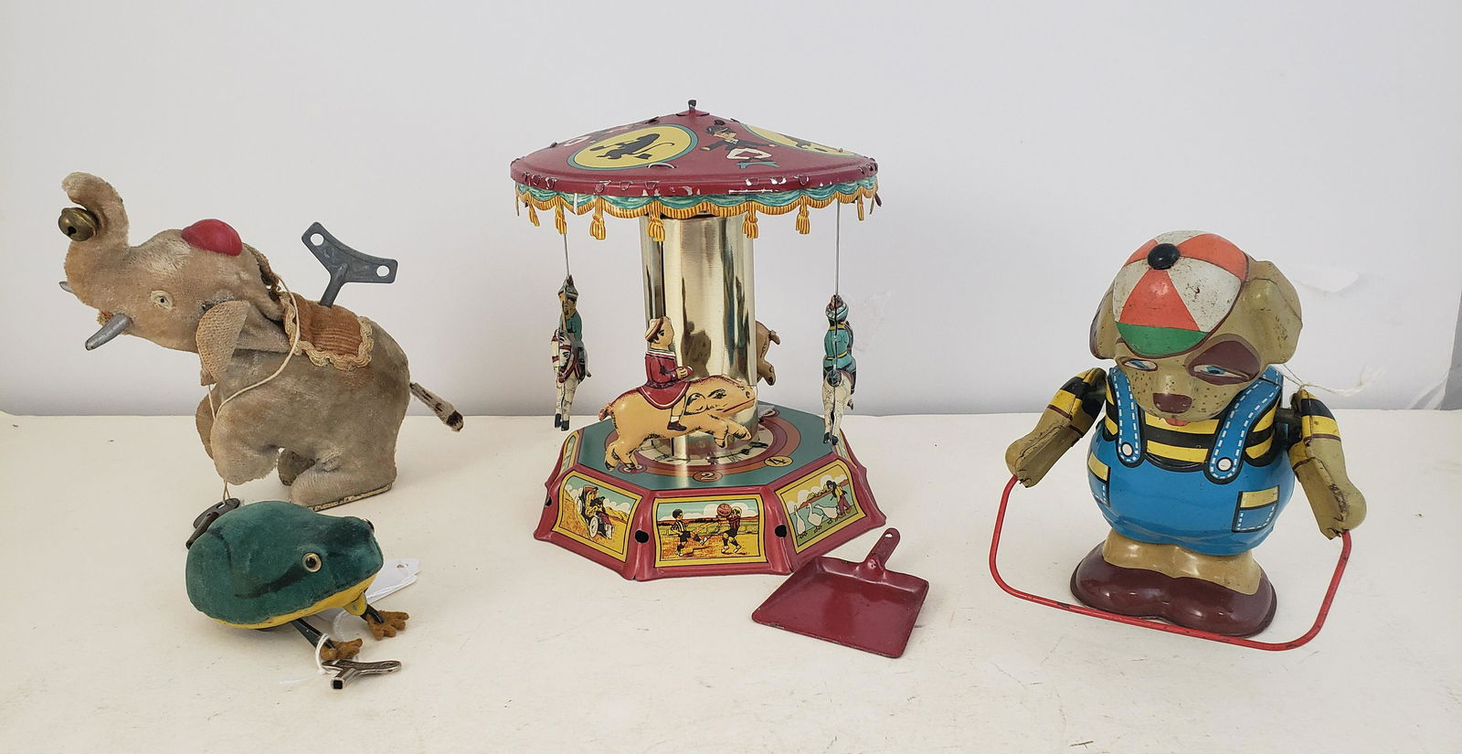 LOT OF 4 TOYS: TIN WIND-UP BEAR JUMPING ROPE, MERRY GO: LOT OF 4 TOYS: TIN WIND-UP BEAR JUMPING ROPE, MERRY GO ROUND, CLOTH COVERED ELEPHANT, AND SCHUCCO CLOTH COVERED FROG