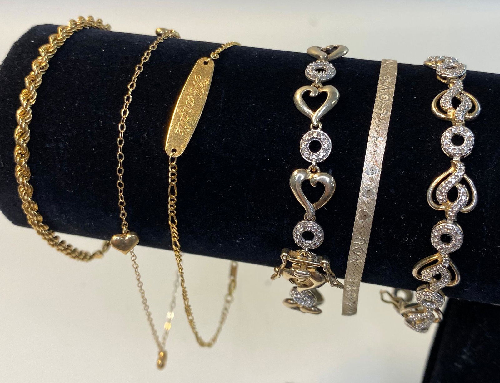 SIX BRACELETS: SIX BRACELETS ~ LOT INCLUDES 14KT YELLOW GOLD FIGARO LINK CHAIN BRACELET WITH "MARGIE" NAME PLATE (1.4 GRAMS TW) TWO 10KT YELLOW GOLD BRACELETS INCLUDING 7.5" SPIRAL CHAIN & 9.5" ANKLET CURB LINK W/ H
