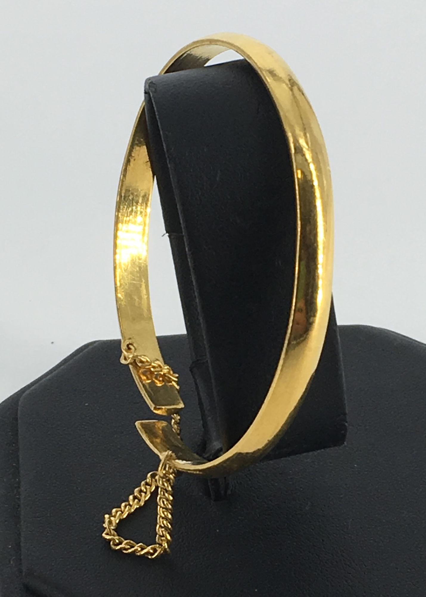 23KT+ YELLOW GOLD BANGLE APPROX 2.125" DIAMETER: 23KT+ YELLOW GOLD BANGLE APPROX 2.125" DIAMETER ADJUSTABLE SIZE WITH SAFETY CHAIN STAMPED AND TESTED (27.9 GRAMS TW)