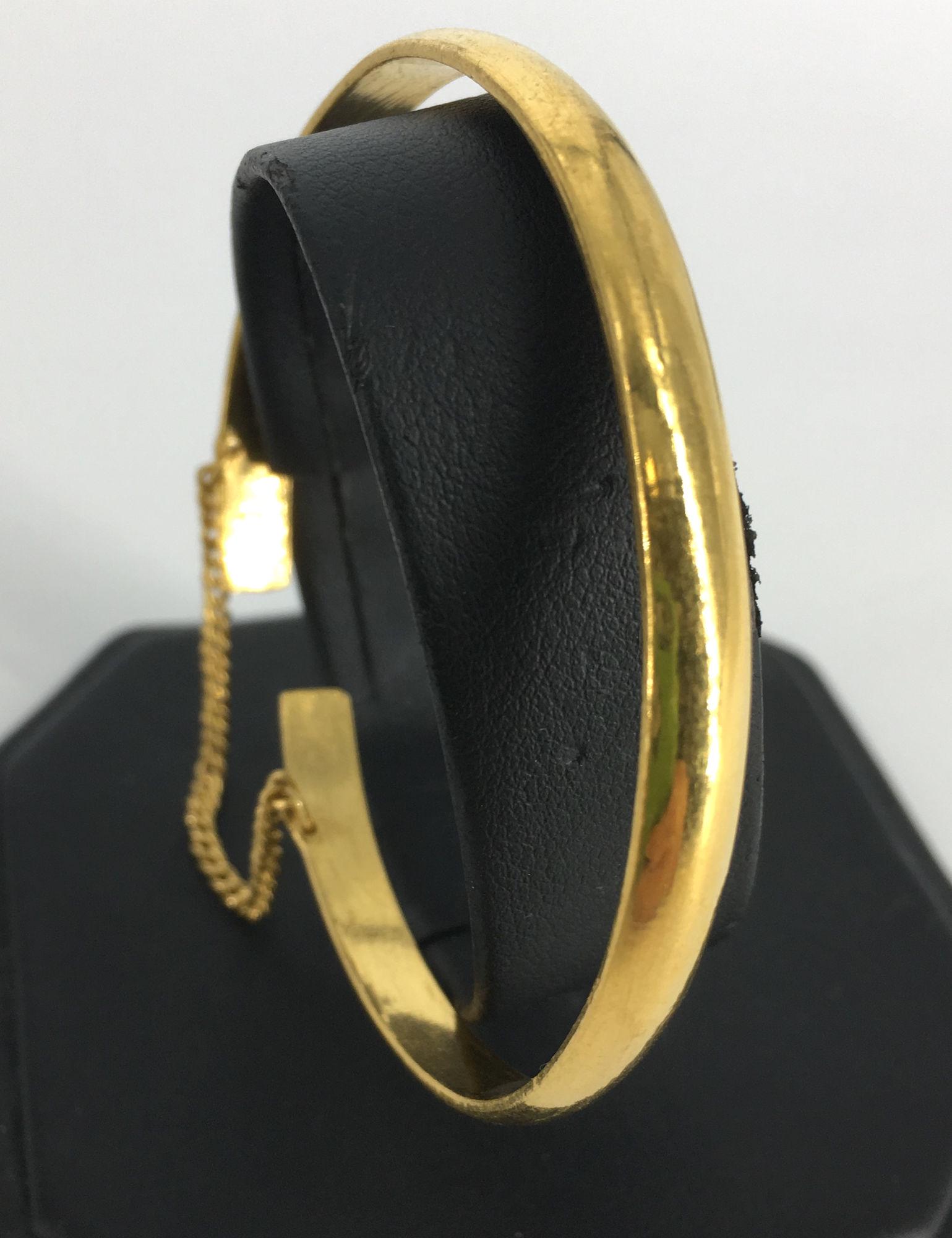 23KT+ YELLOW GOLD BANGLE: 23KT+ YELLOW GOLD BANGLE ~ APPROX. 2.25" DIAMETER, OPEN SHANK (ADJUSTABLE SIZE) WITH SAFETY CHAIN, STAMPED AND TESTED (28.1 GRAMS TW)