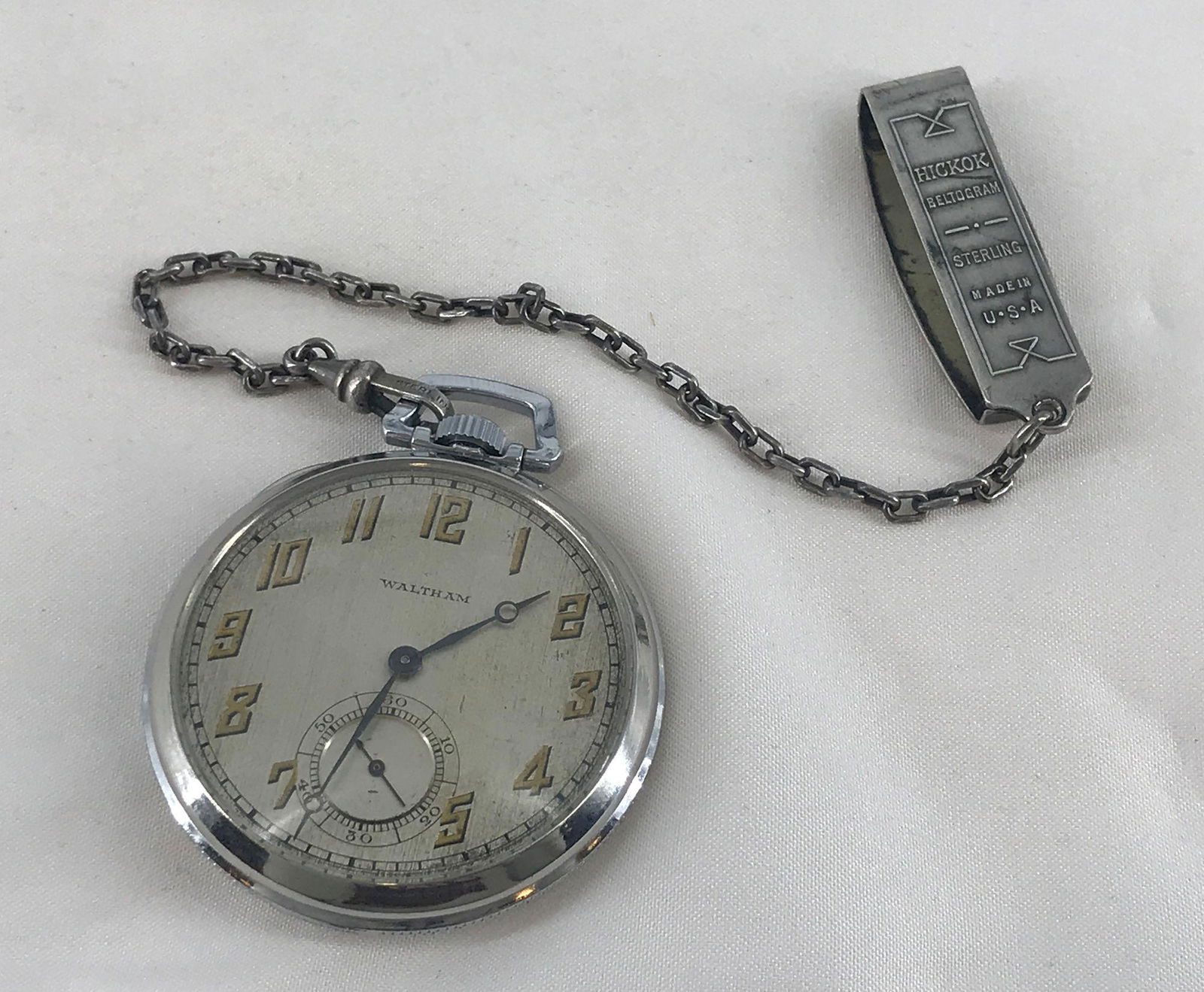 WALTHAM POCKET WATCH ON FOB: WALTHAM POCKET WATCH ON FOB ~ ON SMALL CHAIN WITH CLIP FROM HICKOK. DOES NOT WIND, SET OR TICK. 17-JEWEL MOVEMENT NUMBERED 23977011. STAINLESS BACK AND BEZEL.