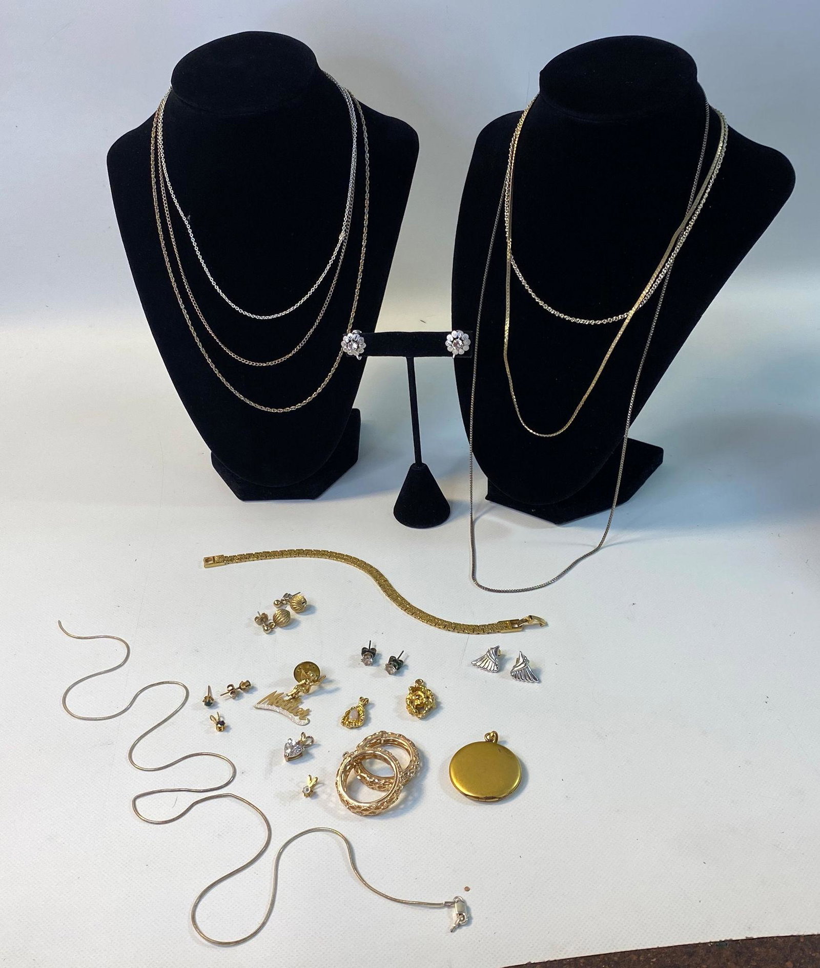 GOLD AND SILVER TONE METAL JEWELRY LOT: GOLD AND SILVER TONE METAL JEWELRY LOT ~ ONE STERLING SILVER CHAIN NECKLACE (BROKEN/0.165 TROY OUNCES TW). SEVERAL GOLD AND SILVER TONE METAL CHAIN NECKLACES. VINTAGE LOCKET (SIGNED). GOLD TONE METAL 