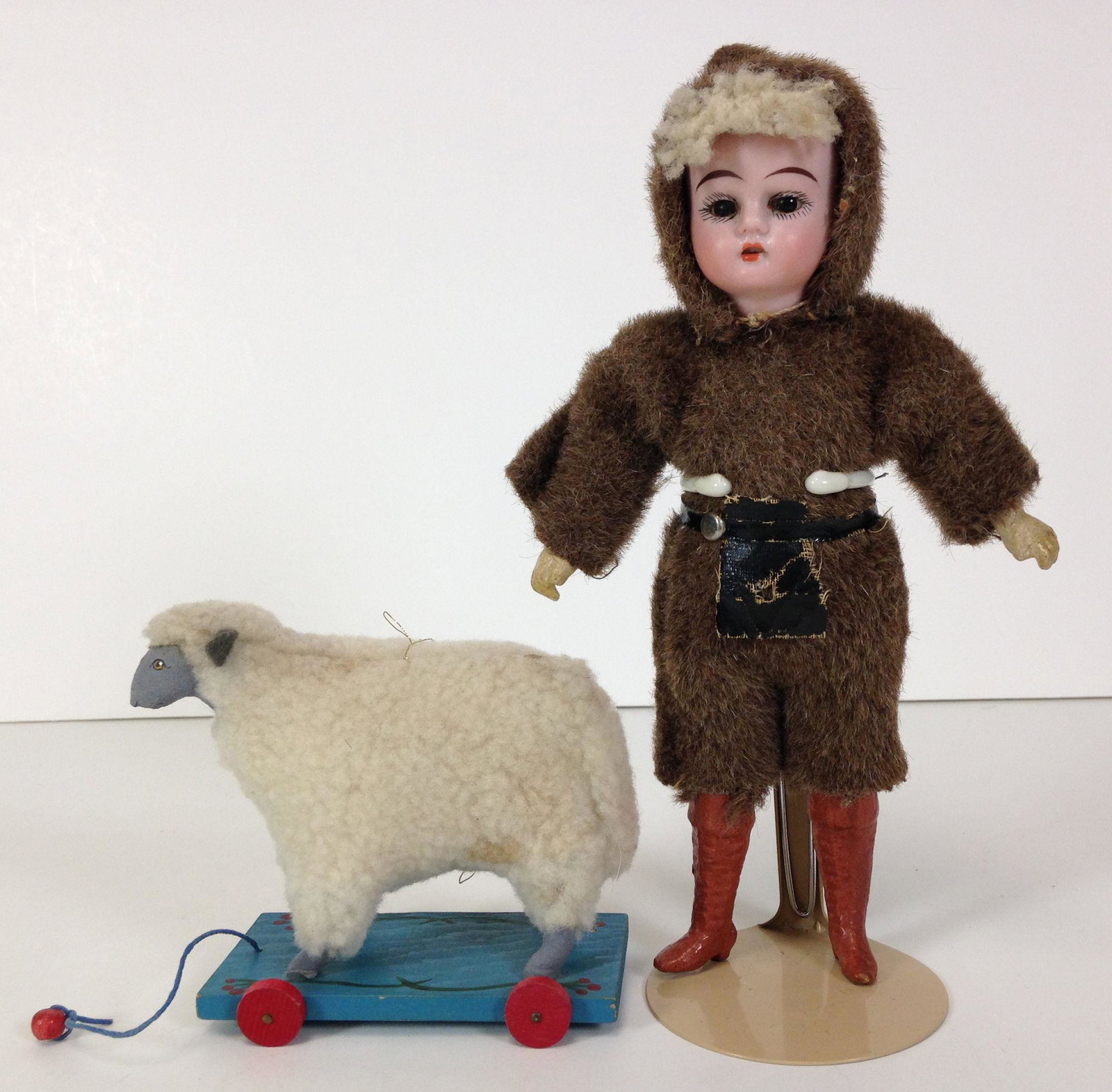 9" GERMAN BISQUE HEAD CHILD. SOCKET HEAD, SMALL PIECE: 9" GERMAN BISQUE HEAD CHILD. SOCKET HEAD, SMALL PIECE SKIN WIG AT FOREHEAD, GLASS SET EYES AND OPEN MOUTH WITH TEETH. ON FIVE-PIECE COMPOSITION BODY WITH MOLDED AND PAINTED TALL BOOTS. WEARS "FUR" SUI