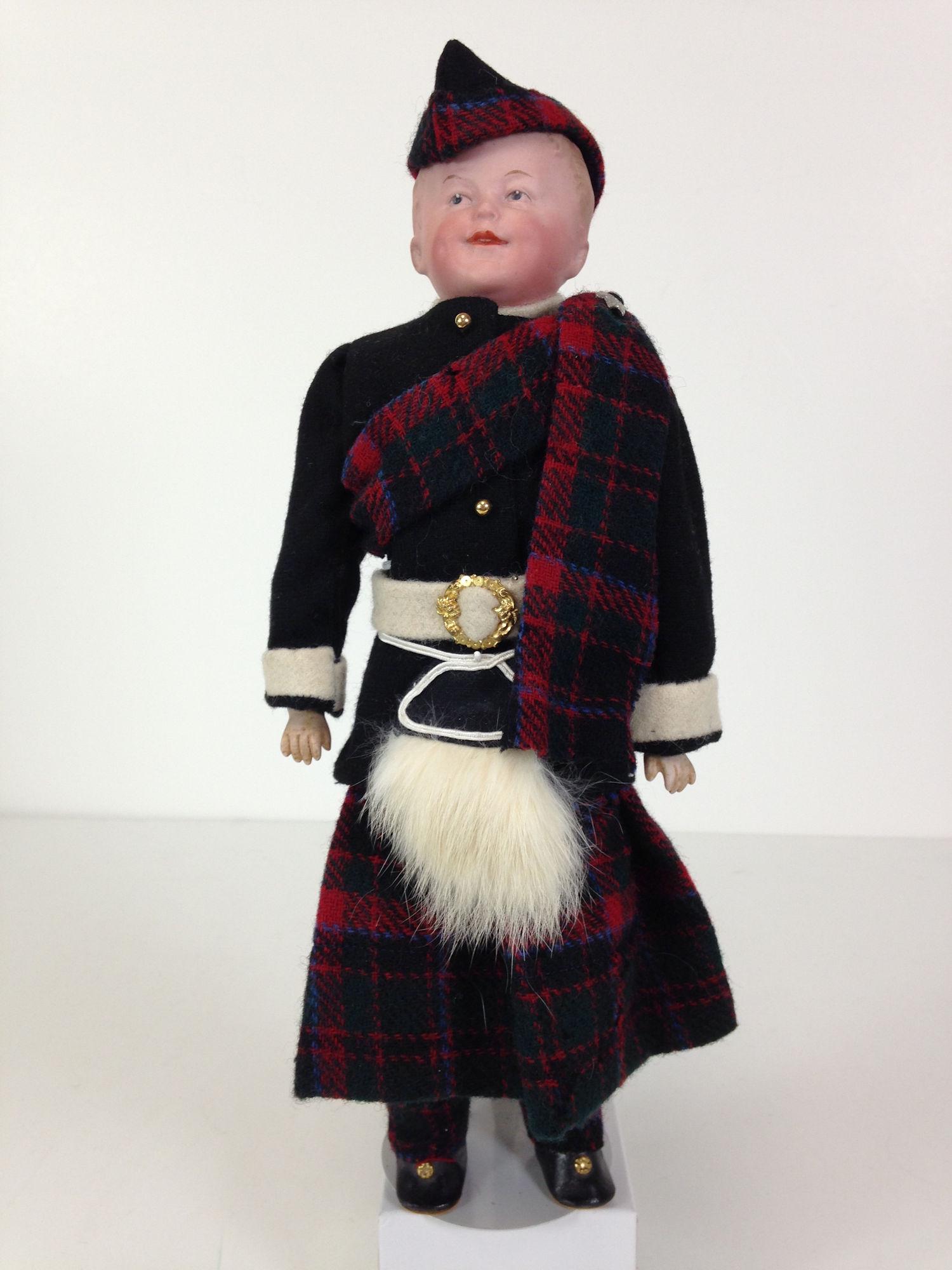 13" GBR. HEUBACH BISQUE SHOULDER HEAD SMILING BOY IN: 13" GBR. HEUBACH BISQUE SHOULDER HEAD SMILING BOY IN SCOTTISH UNIFORM. MOLDED AND PAINTED HAIR, INTAGLIO EYES AND OPEN/CLOSED MOUTH WITH MOLDED TWO UPPER TEETH. ON RIVET JOINTED KID BODY WITH BISQUE L