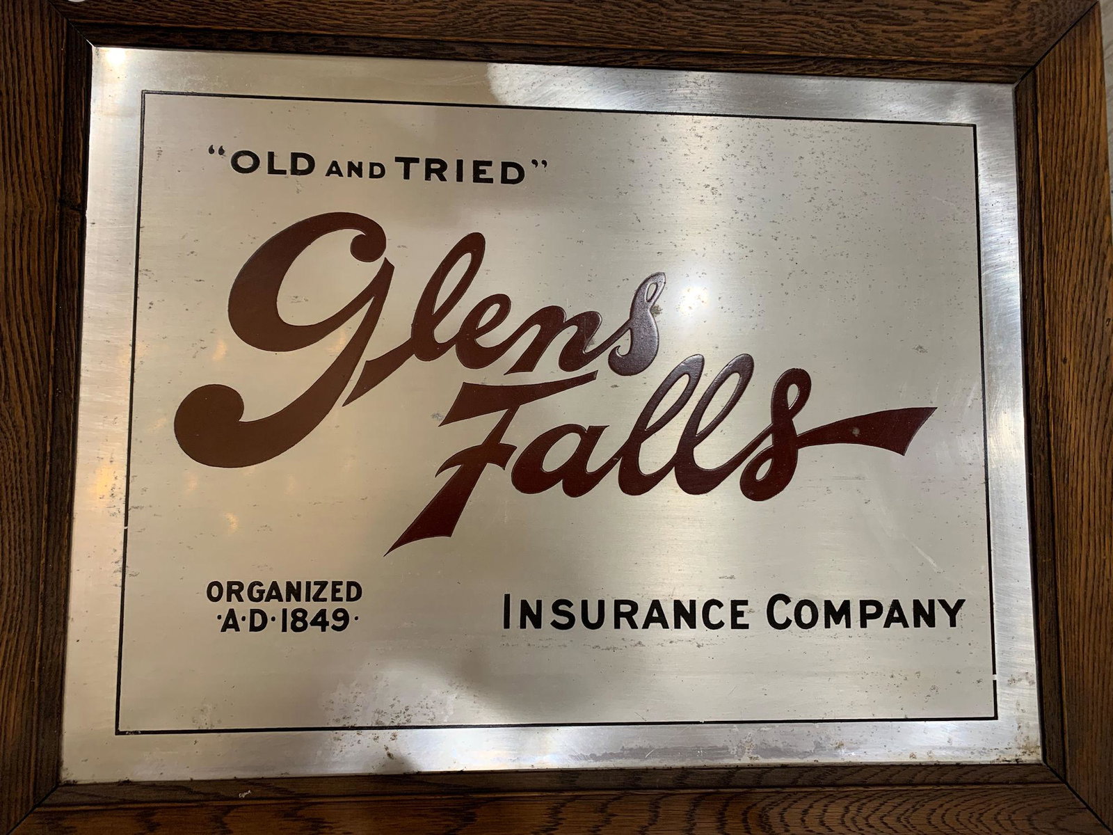 WOOD FRAMED TIN ADVERTISEMENT SIGN "GLENS FALLS: WOOD FRAMED TIN ADVERTISEMENT SIGN "GLENS FALLS INSURANCE" MEASURING 28½" X 22½".
