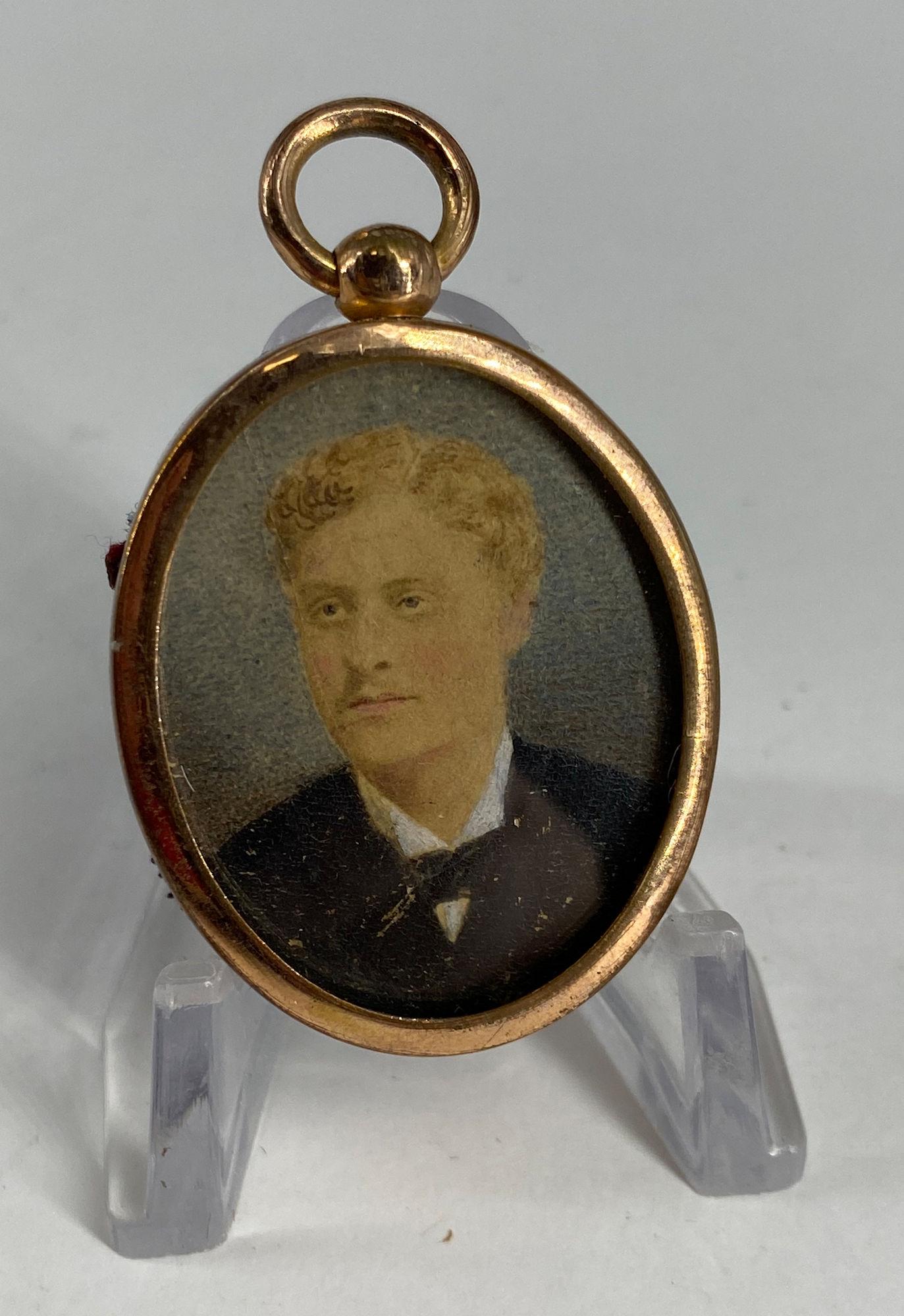 VINTAGE PENDANT: VINTAGE PENDANT ~ 1.875" IN LENGTH, LOCKET STYLE PENDANT WITH COPPER TONE BEZEL CONTAINING A VINTAGE PORTRAIT OF A MAN IN A BLUE SUIT, UNSIGNED WITH RED VELVET BACK