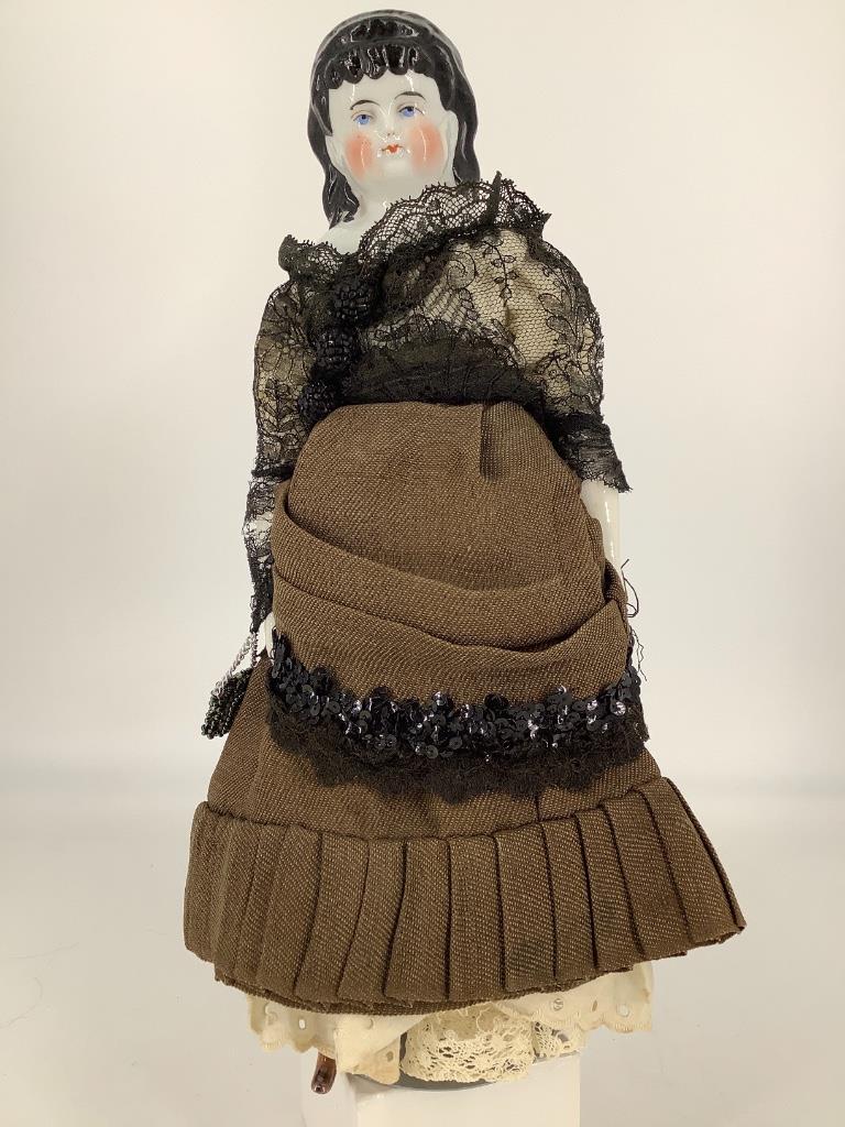 12" China Head Spillcurl lady. Molded and painted hair: 12" China Head Spillcurl lady. Molded and painted hair and facial features, exposed ears, on replaced cloth body with china lower arms and legs, luster shoes, dressed in antique fabrics. Few kiln spec