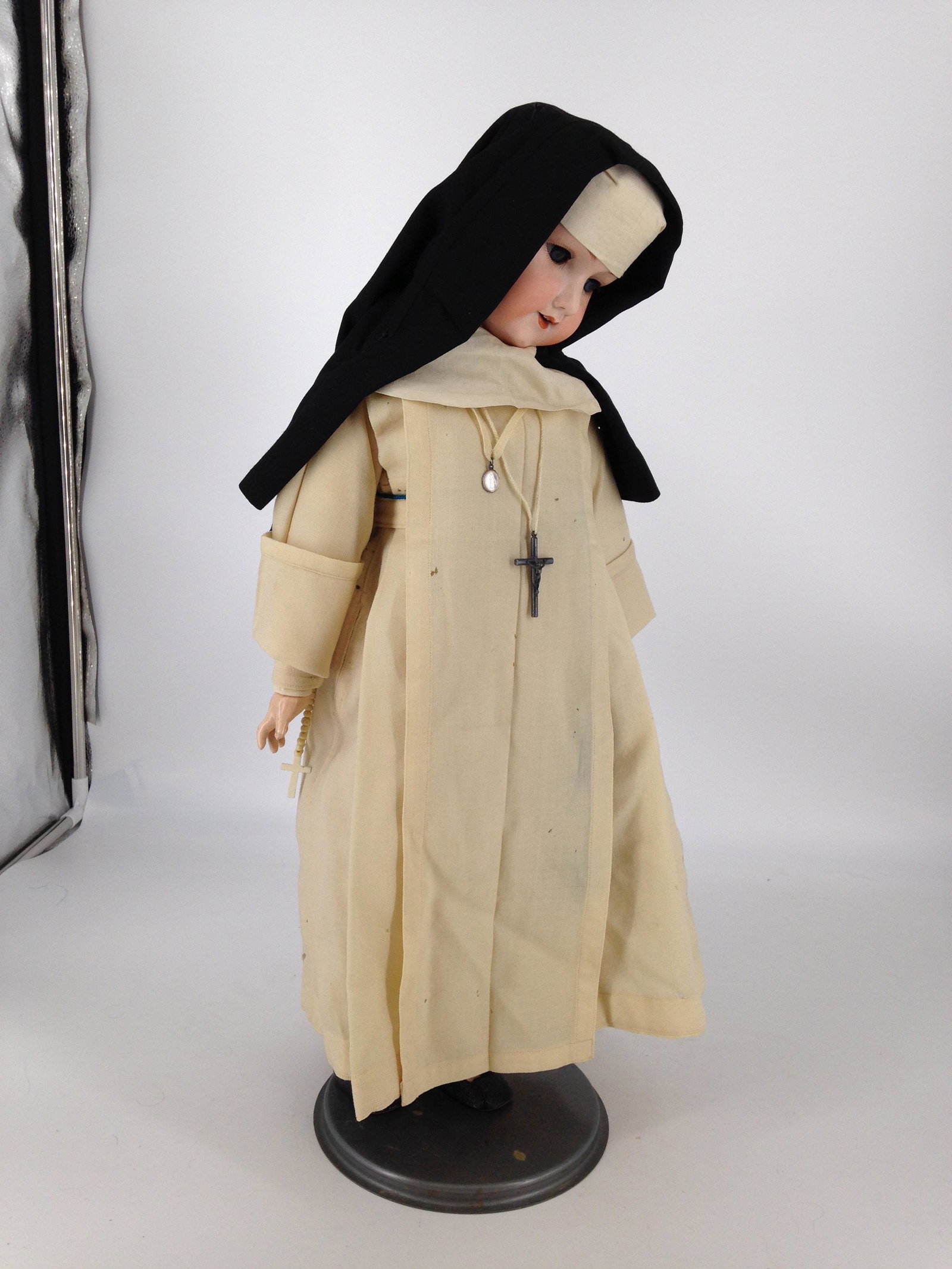 23" ARMAND MARSEILLE 390 BISQUE SOCKET HEAD NUN. GLASS: 23" ARMAND MARSEILLE 390 BISQUE SOCKET HEAD NUN. GLASS SLEEP EYES, OPEN MOUTH WITH TEETH, ON JOINTED COMPOSITION BODY. DRESSED IN WOOL NUN'S HABIT COMPLETE WITH CRUCIFIX AND ROSARY.