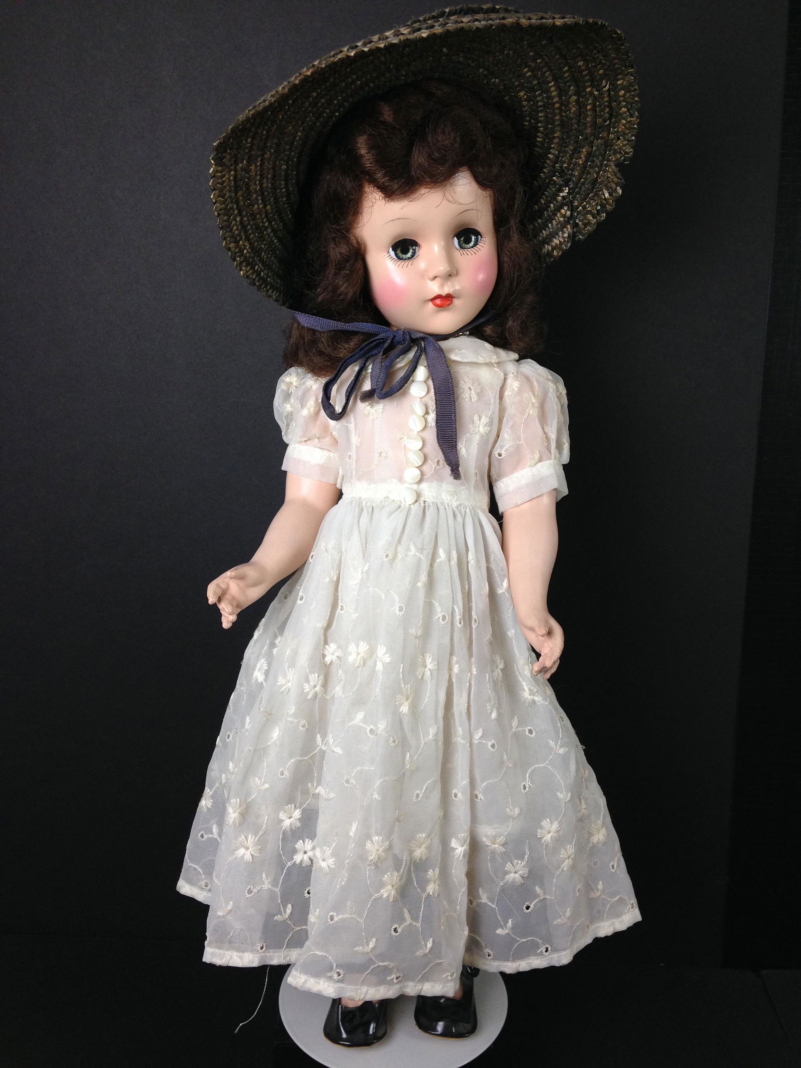17" VINTAGE UNMARKED HARD PLASTIC MARGARET FACE DOLL: 17" VINTAGE UNMARKED HARD PLASTIC MARGARET FACE DOLL WEARING VINTAGE STRAW HAT AND VINTAGE WHITE EMBROIDERED DRESS WITH EYELETS, UNDERGARMENT AND STOCKINGS; REPLACED SHOES.