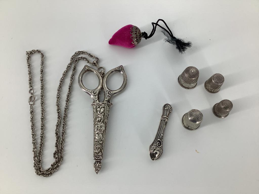 A lot of sterling and plated sewing accessories: A lot of sterling and plated sewing accessories including scissors in a case and thimbles.