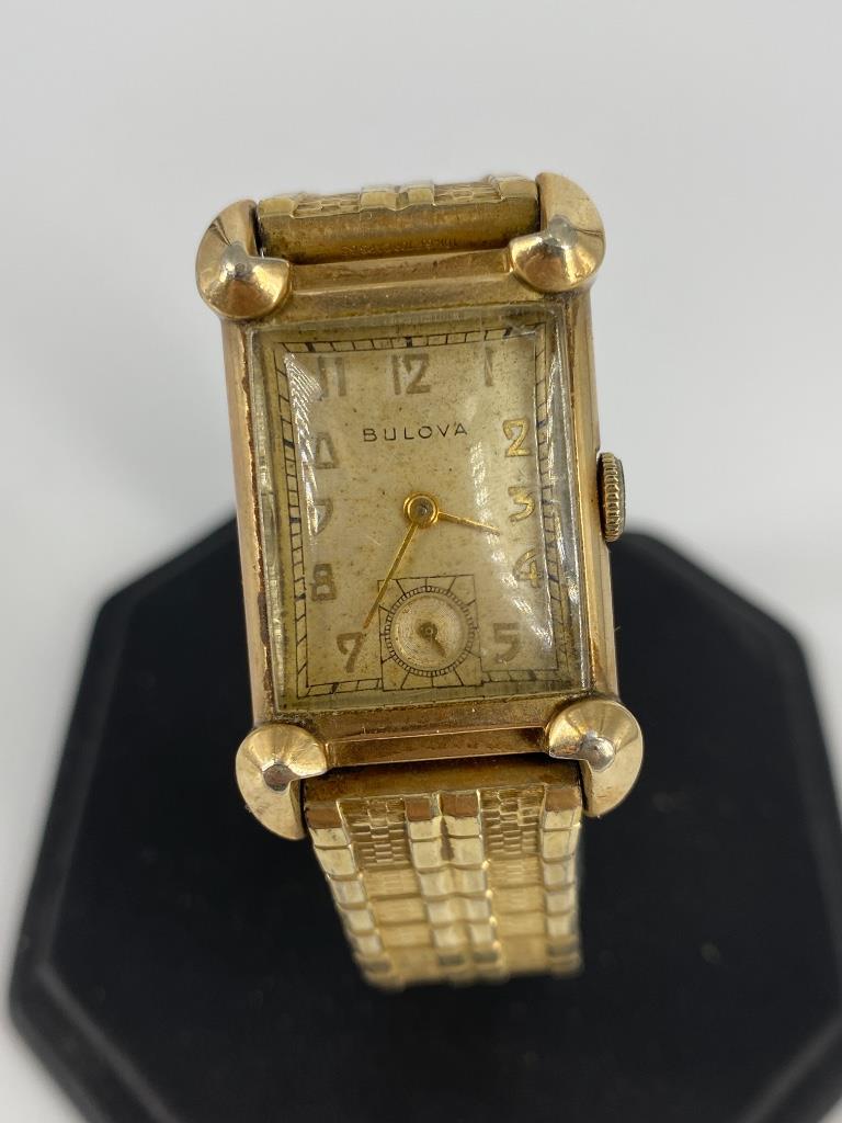 Vintage Bulova Wrist Watch: Vintage Bulova Wrist Watch 10kt gold-filled case and caps (on Speidel stretch band). Winds, sets and ticks at time of listing. Numbered 9835303. Off-white face with gold tone metal hands and indicator