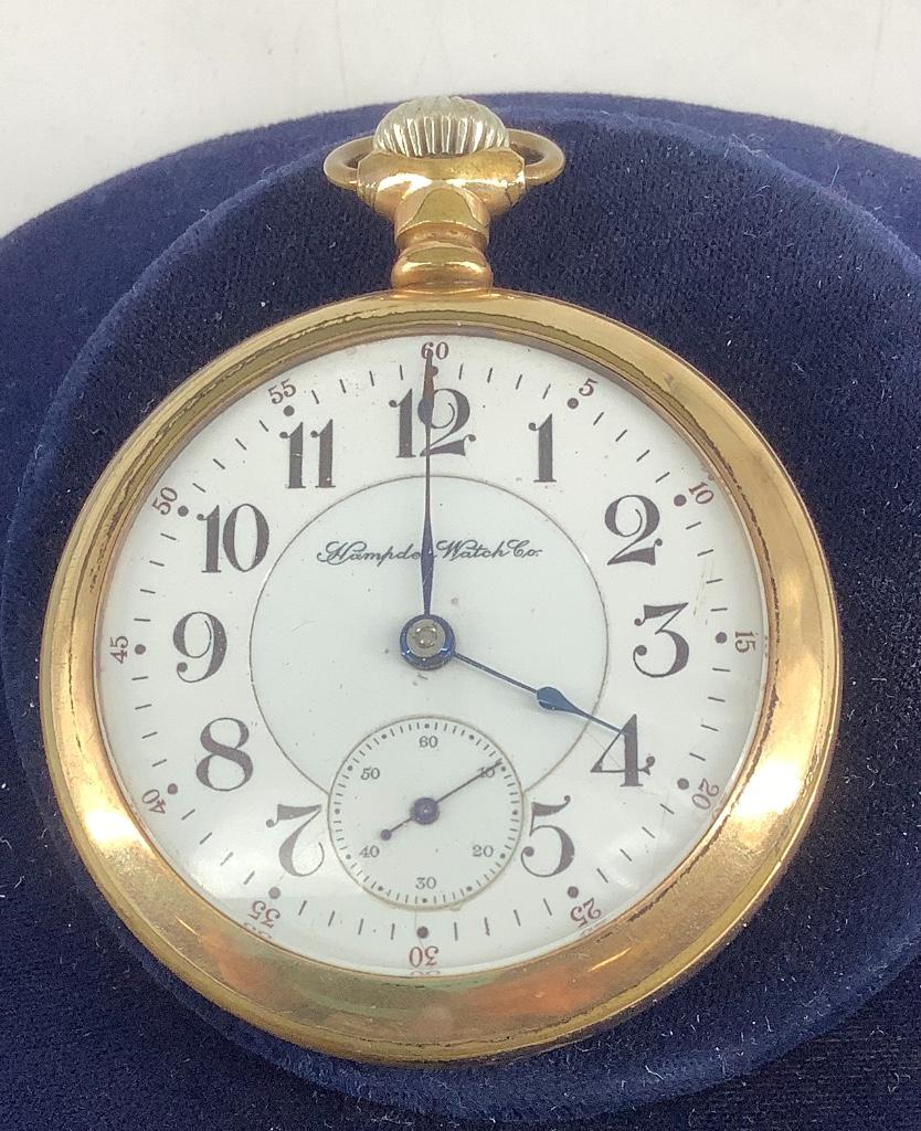 Hampden Pocket Watch: Hampden Pocket Watch Winds, sets and ticks at time of listing. White face with black numeric indicators. Open face movement setting. Lever set. Swing-out case. 55.0 mm in diameter. Case has obvious we