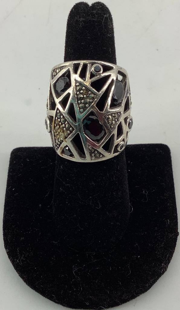 Sterling Silver Ring: Sterling Silver Ring Modern design with oval and round cut black onyx stones and marcasite adornments. Stamped and tested 925. Size 6.5. Polished metal finish. 0.435 troy ounces total weight.