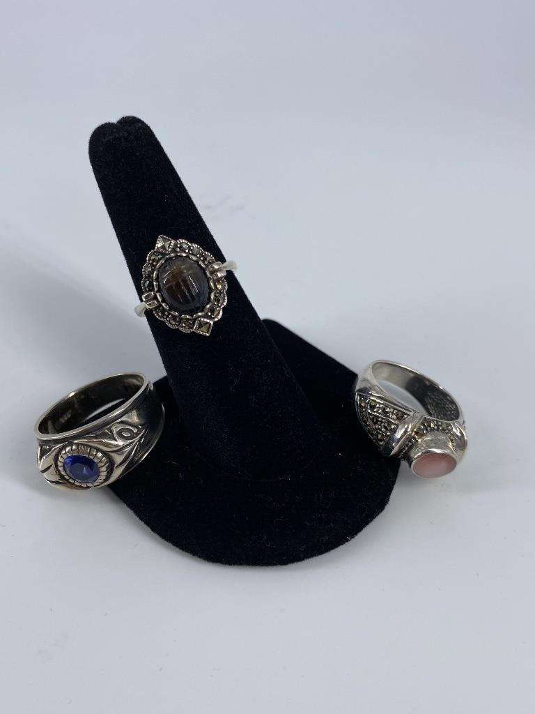 Three Sterling Silver Rings: Three Sterling Silver Rings Size 6.75 reverse tapered shank ring featuring a carved scarab style semi-precious stone accented with marcasite accents, size 10, tapered shank ring featuring a natural em
