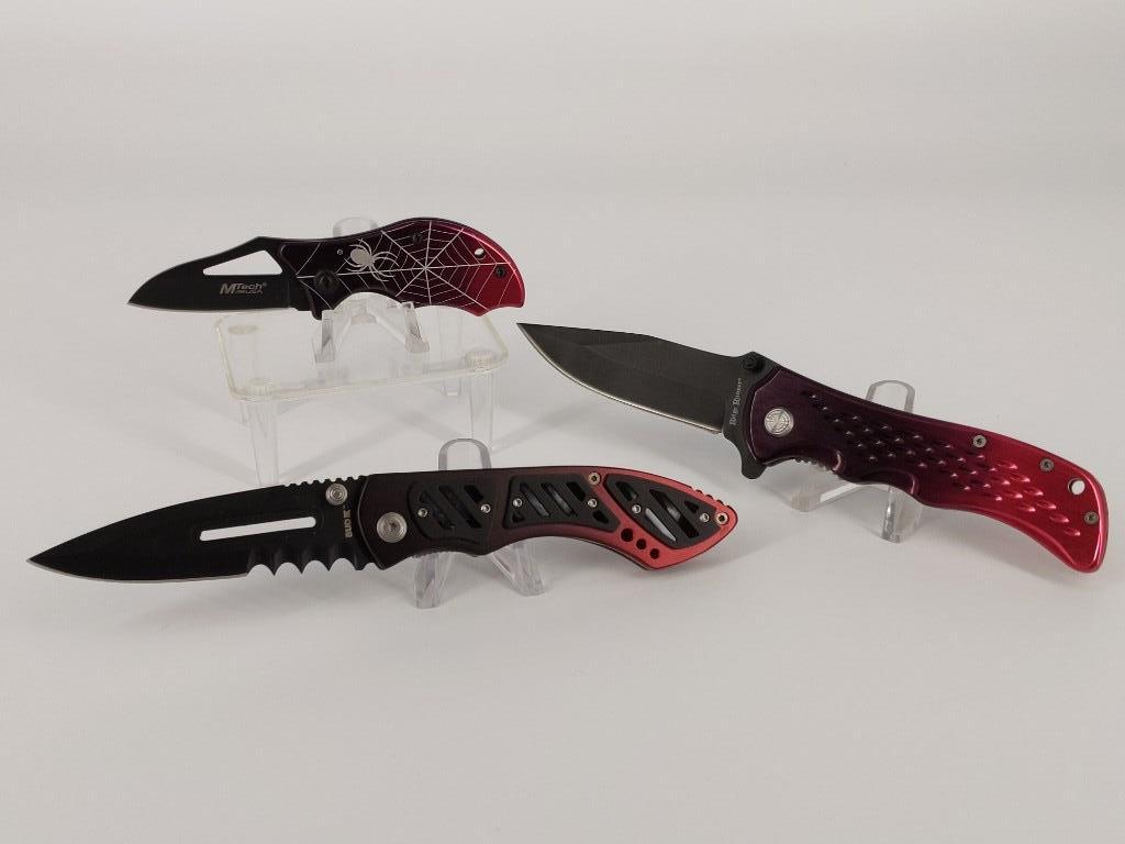 Lot of Three Folding Knives: Lot of Three Folding Knives Modern styles with two-tone metal scales, 4.875" - 8" in length. Clip point, wharncliffe and spear point blades. Styles from Ridge Runner, BudK and MTech. Handcrafted Chine