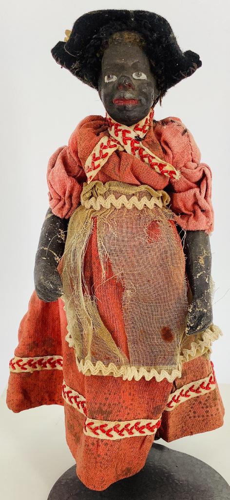 6 1/2" Black papier mache lady. One-piece head and: 6 1/2" Black papier mache lady. One-piece head and torso, wire jointed arms and legs, "rug" hair, molded and painted facial features. Doll appears to be all original with considerable wear, glued repa