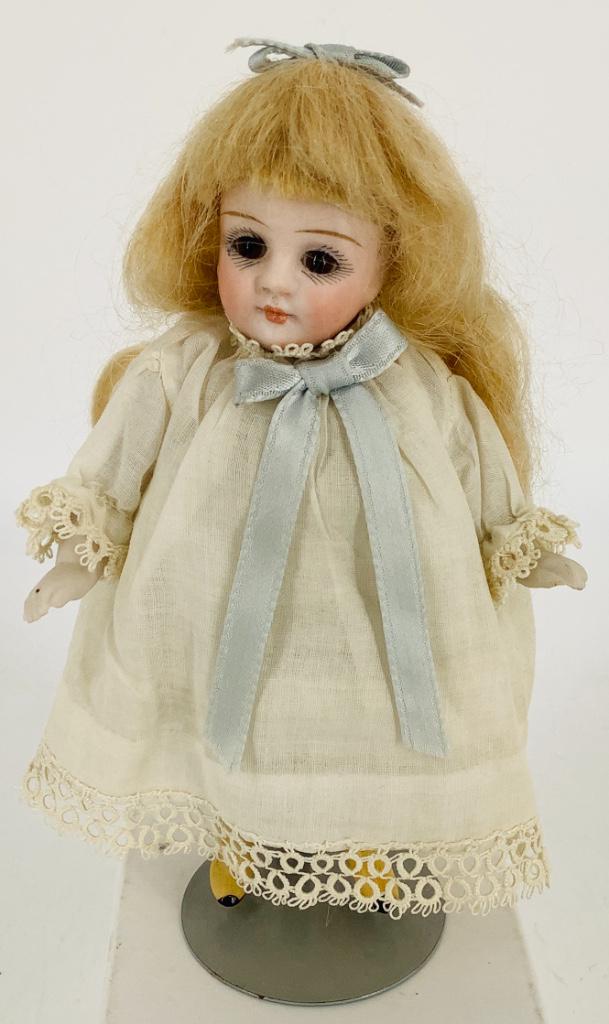 4 1/2" all-bisque girl. Marked 96.5, long mohair wig,: 4 1/2" all-bisque girl. Marked 96.5, long mohair wig, stationary glass eyes, closed mouth, on five-piece peg jointed body, molded and painted yellow boots. Few chips on edge of legs at hip joints, sma