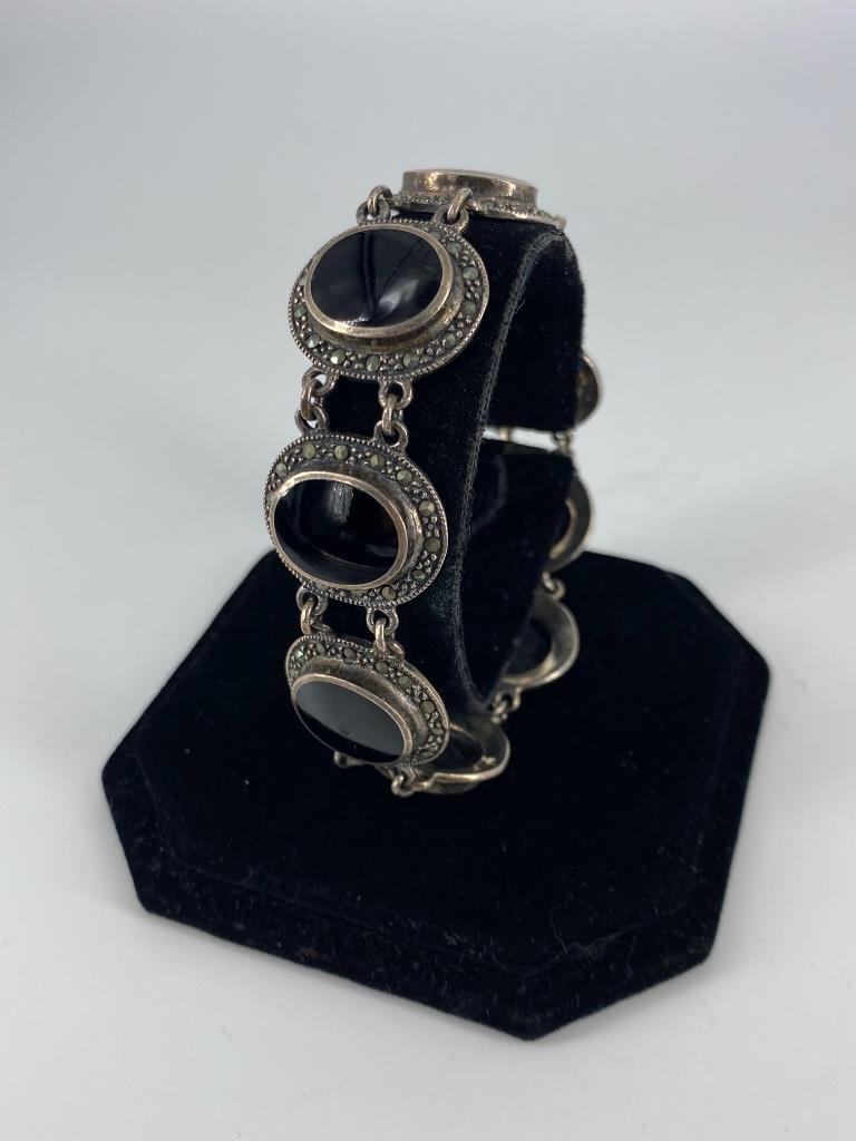 Sterling Silver Onyx & Marcasite Fashion Bracelet: Sterling Silver Onyx & Marcasite Fashion Bracelet 8” in length, 0.82” wide featuring circular links containing onyx center stones surrounded by a halo of marcasite accent stones, stamped a