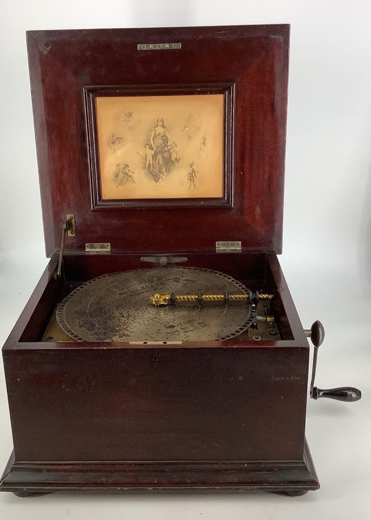 Regina Company disc music box, including eight disc.: Regina Company disc music box, including eight disc. Discs are 12” wide and crank included. Showing some wear on cabinet.