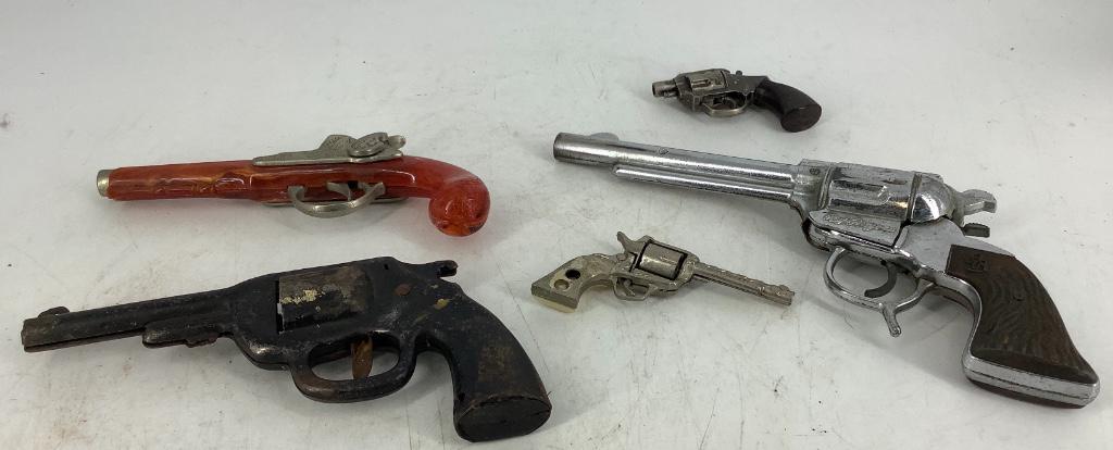 Toy guns ranging from 3” to 10” in size. One is a: Toy guns ranging from 3” to 10” in size. One is a Flintlock Jr.