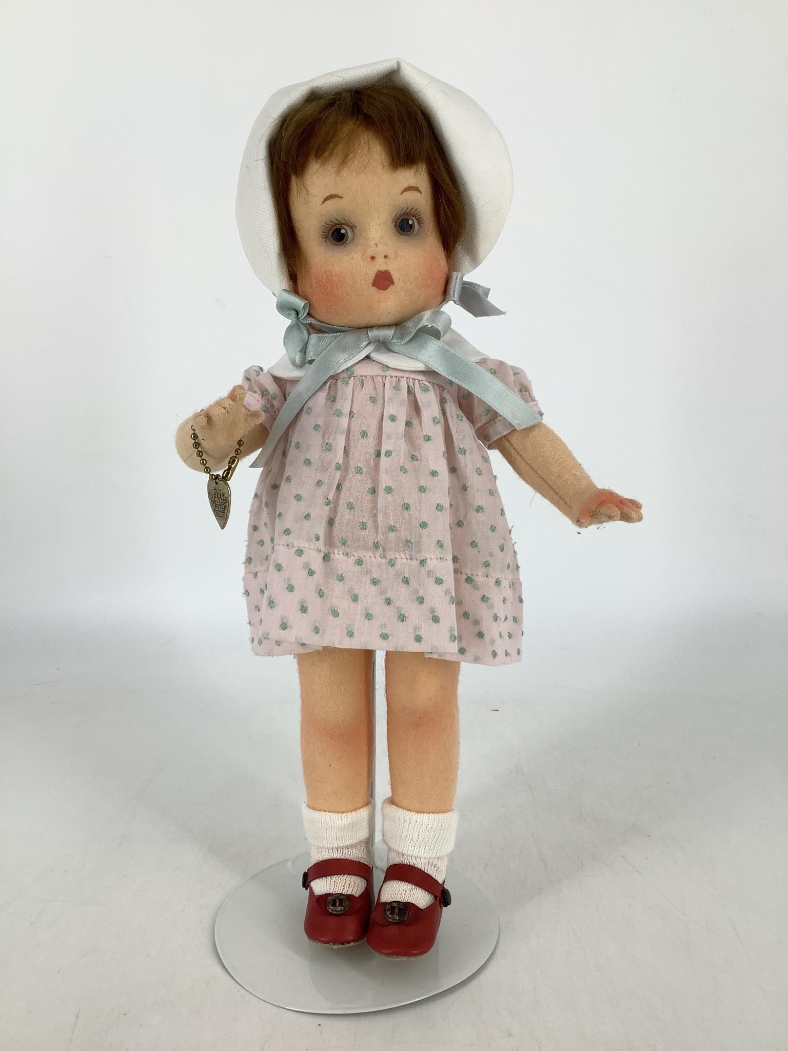 All felt "Patsy" by R. John Wright. 12" doll with: All felt "Patsy" by R. John Wright. 12" doll with molded and painted facial features, mohair wig, on five-piece body with the signature bent right arm. Complete with her RJW heart shaped wrist charm.
