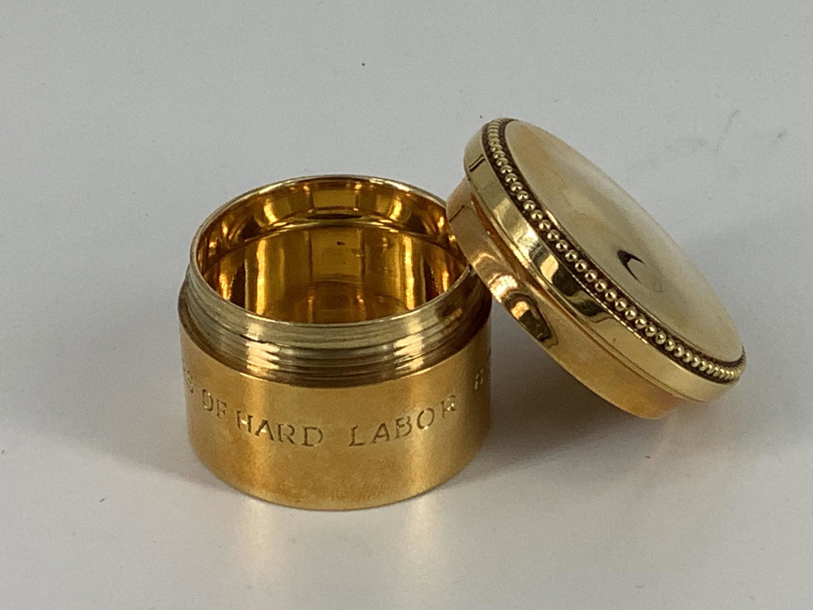 18kt Yellow Gold Cartier Container: Base measures 30mm in diameter, 25.5mm tall, lid measures 35mm in diameter & features beaded accents, stamped, tested, signed & numbers (22302 651) featuring multiple hallmarks & a personal engraving 
