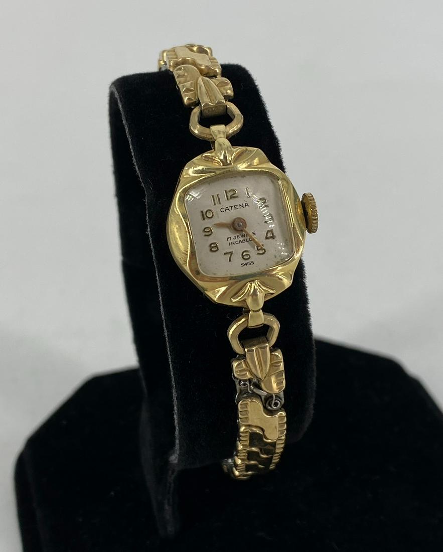Vintage Catenary Ladies Wrist Watch: Vintage Catenary Ladies Wrist Watch Gold tone stretch band featuring embossed accents, 14kt yellow gold case with a white face and gold tone numeric indicators and hands, stamped and tested, 17 jewel 