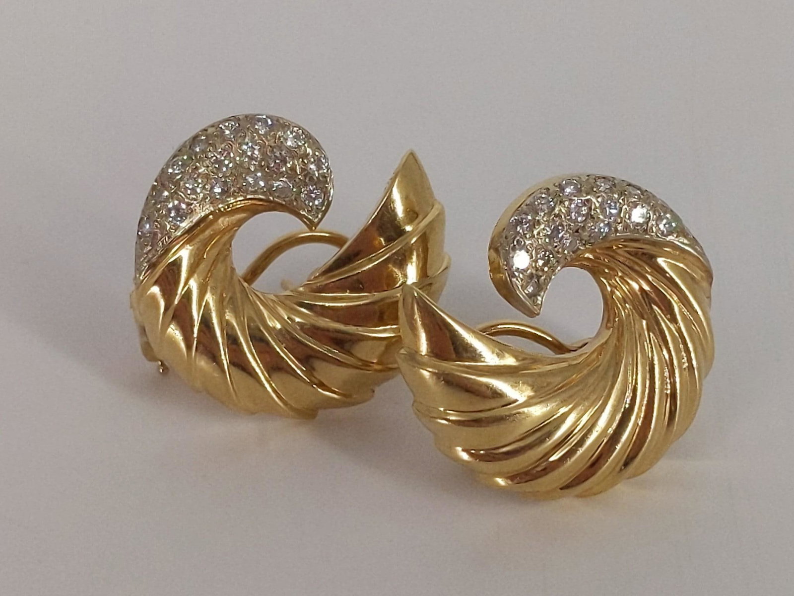 14kt Gold Dual Tone, Omega Back, Diamond Earrings: 14kt Gold Dual Tone, Omega Back, Diamond Earrings 0.4" in length, curved Ã¬CÃ® shaped design featuring ridged layers of polished gold followed by a closure of pave mounted diamonds (34 diamond rou