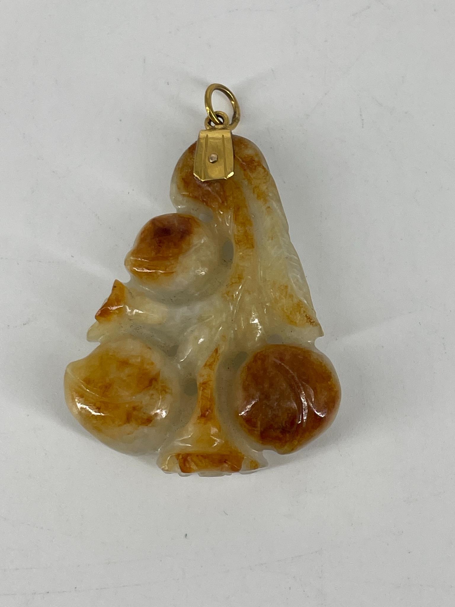 Carved Jade Pendant: Carved Jade Pendant 14kt gold bail, pendant measures 51.25mm x 37.0mm in size, natural motif, orange/pale green coloration.