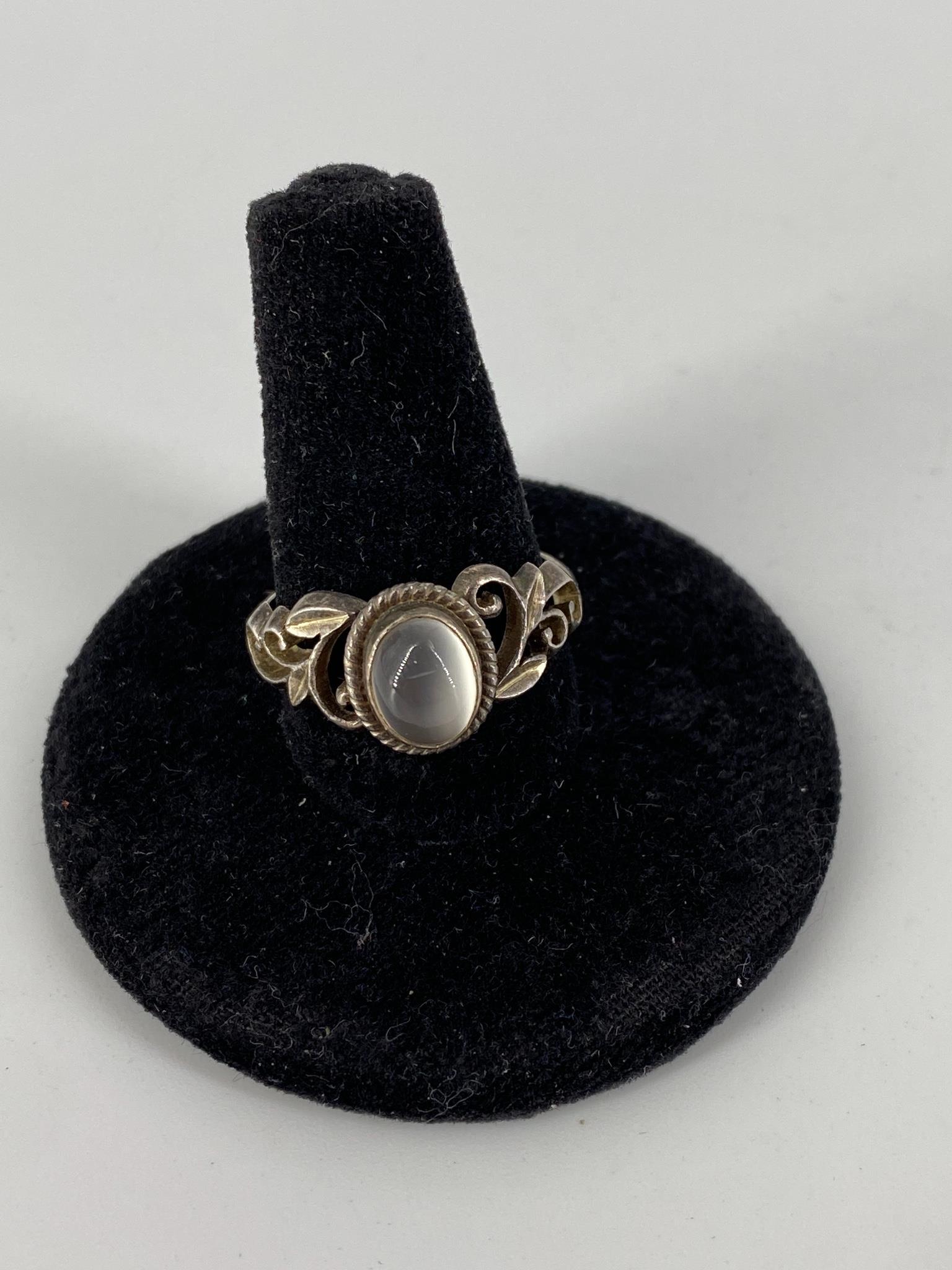 Sterling and Stone Ring: Sterling and Stone Ring Stamped and tested, 3.8 grams tw., size 8, shank features natural motif, bezel set 8.75mm x 6.75mm moonstone cabochon in center accented with rope style bezel adornment.