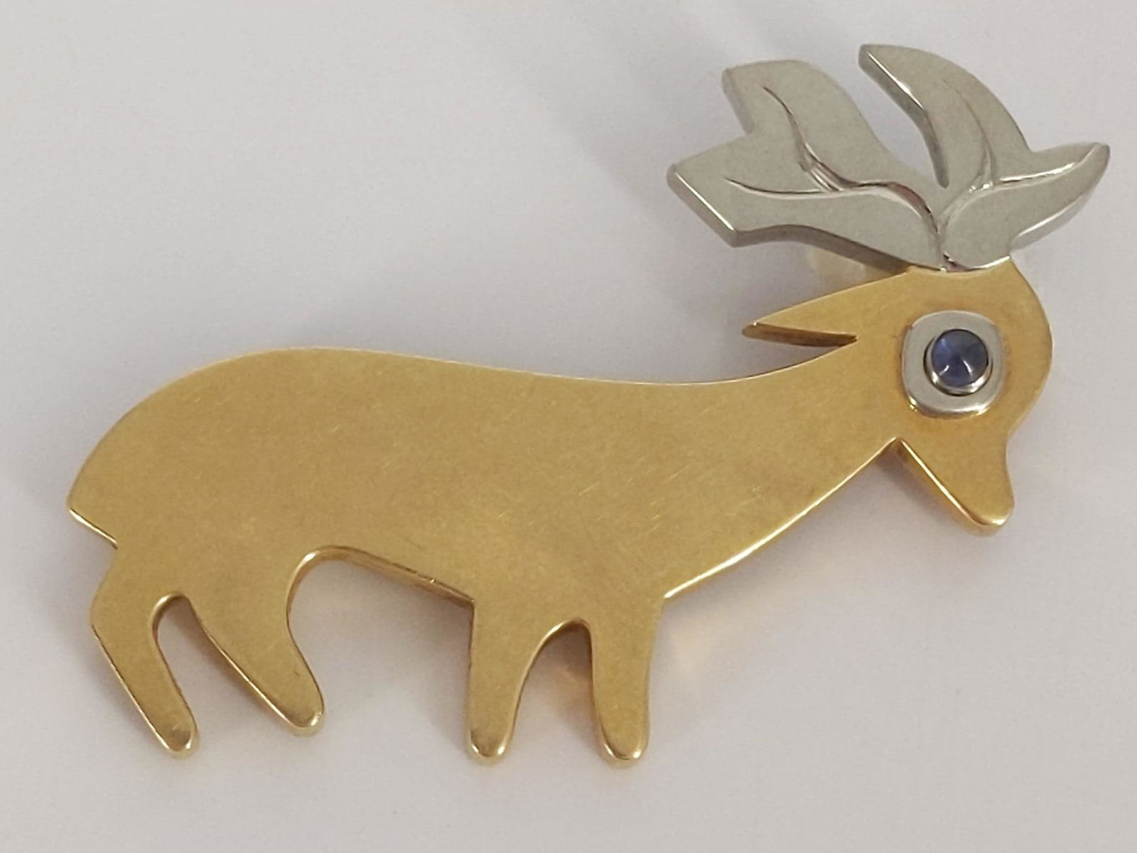 18kt Yellow Gold Deer Pin with Blue Sapphire Gemstone: 18kt Yellow Gold Deer Pin with Blue Sapphire Gemstone Eye Stamped and tested, signed Gardberg (Bertel Gardberg). 21.6 grams total weight. 2.25" in length, polished metal finish. White gold antlers wit