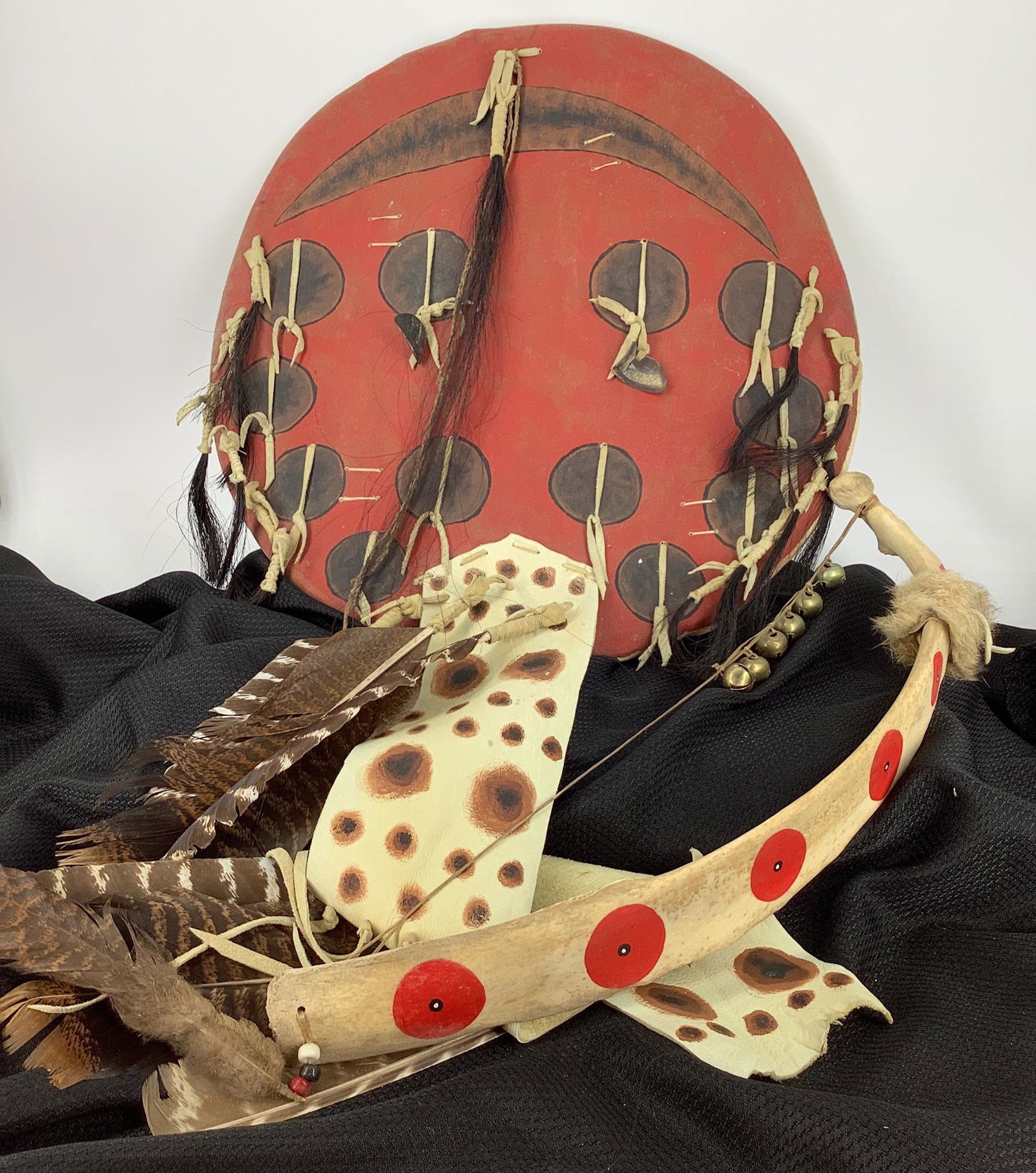 Lot of two Native American type items including a bow: Lot of two Native American type items including a bow made from what looks to be bone, strung with bells and has feather and fur embellishments with painted symbols, 19” long. Lot Includes a shi