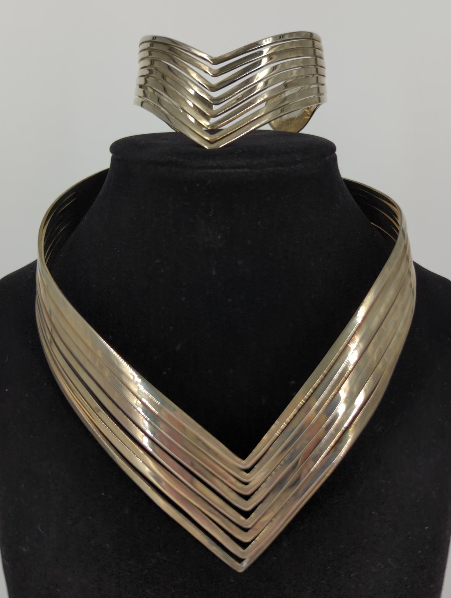 Silver Tone Jewelry Set: Silver Tone Jewelry Set This lot includes a matching necklace and bracelet, choker length neckalce features a â€œVâ€™ shaped design with a polished finish, the bracelet features an inner diam