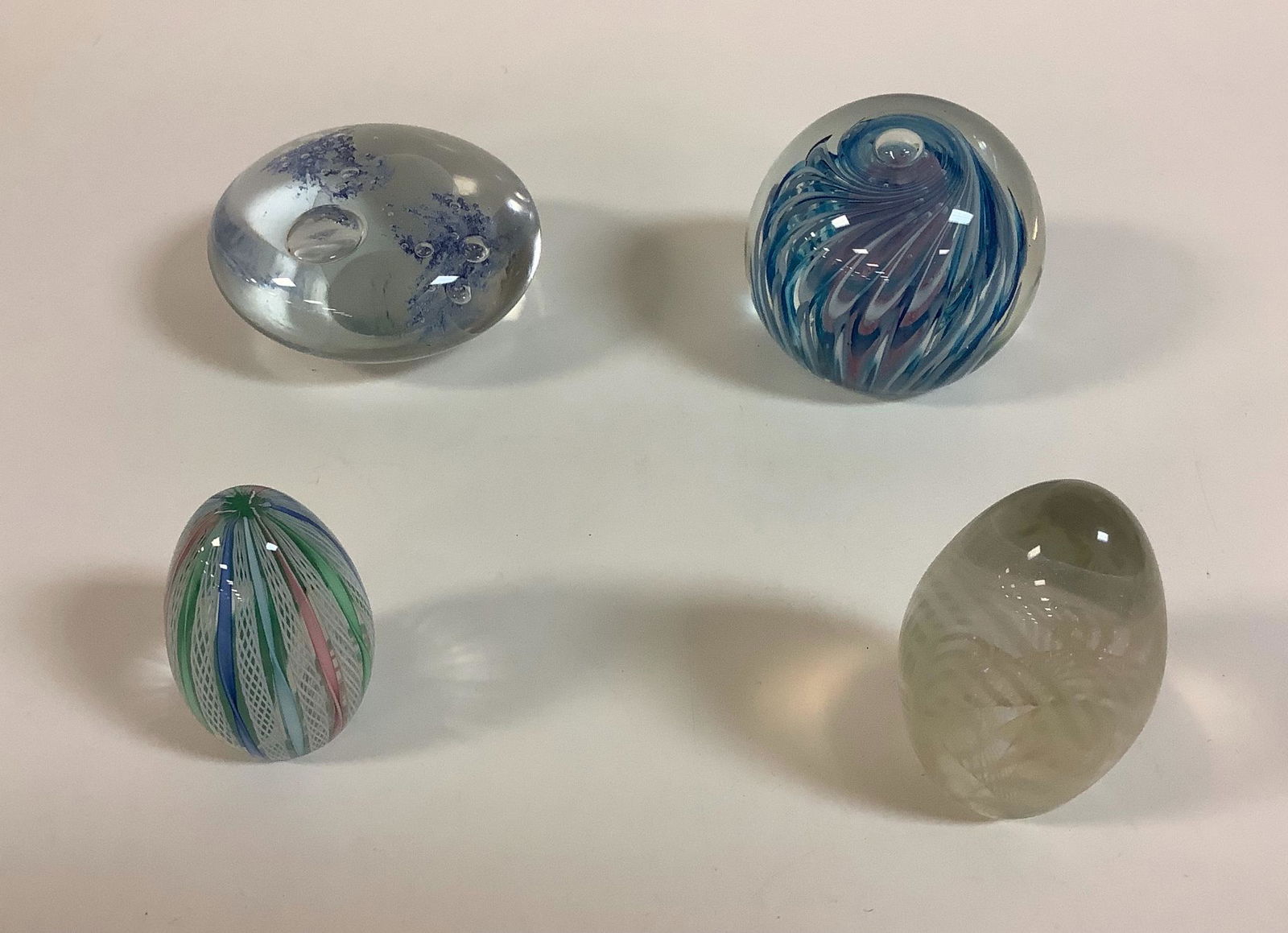 4 glass paperweights measuring 2"-3.25", one labeled (1 of 2)