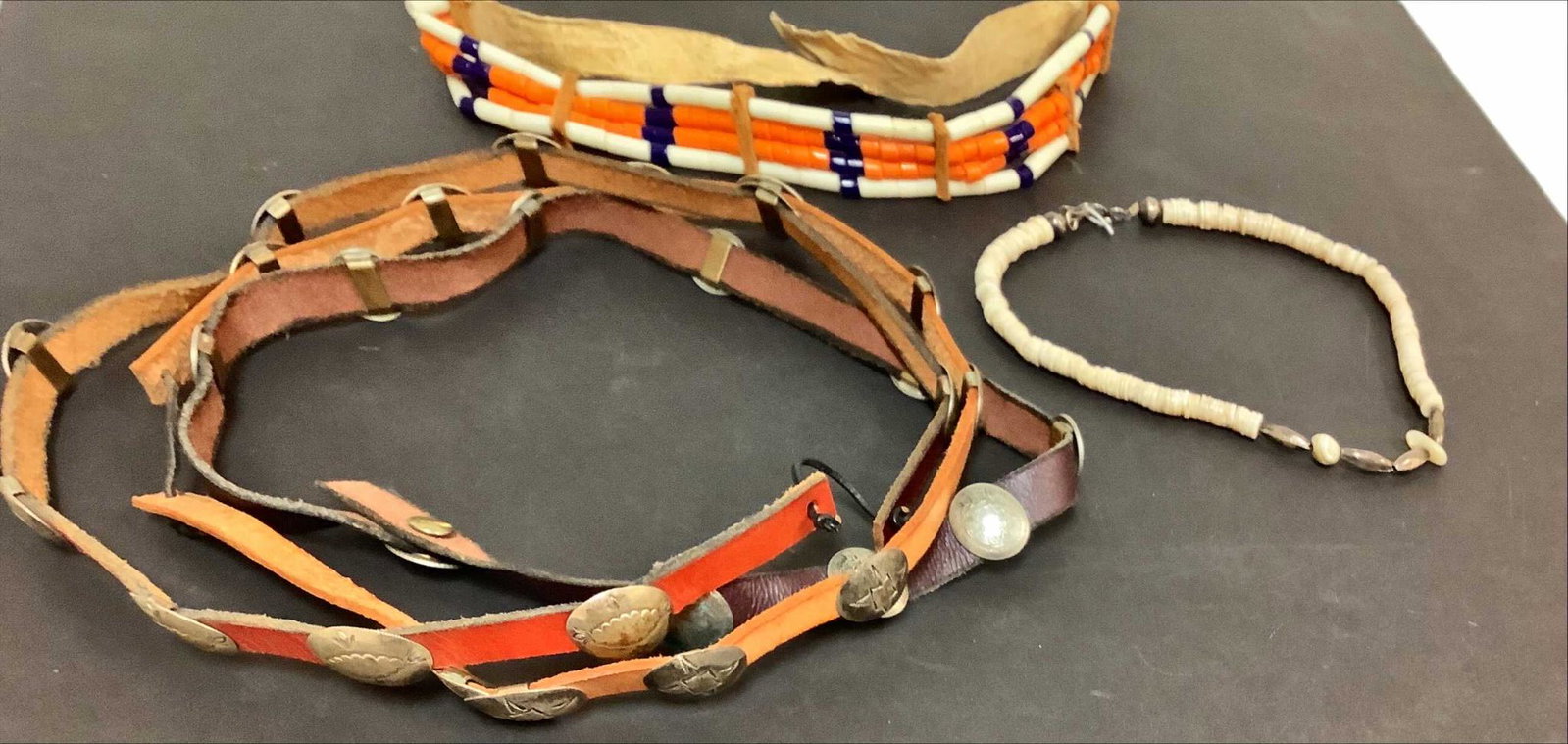 3 hat band with leather and conchos. One Native choker: 3 hat band with leather and conchos. One Native choker made of bone leather and beads and a Native necklace.