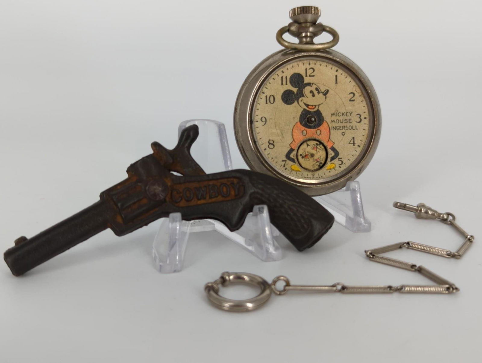 Toy Gun, Pocket Watch and Silver Tone Watch Chain: Toy Gun, Pocket Watch and Silver Tone Watch Chain Small cast iron toy gun (antique - vintage age) measuring 3.5" in length (with action). Vintage Mickey mouse/Ingersoll pocket watch missing hands and