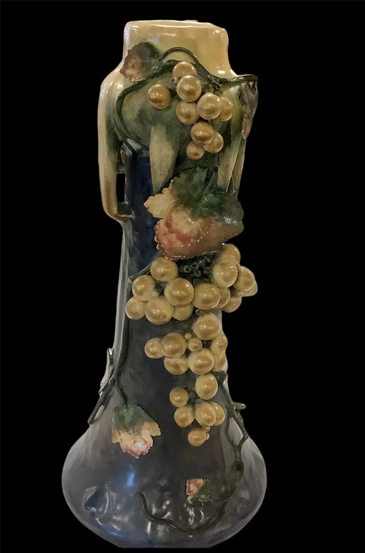 Amphora vase 17" with grapevines motif comes from the firm of Riessner. It has the EDDA mark on: Amphora vase 17" with grapevines motif comes from the firm of Riessner. It has the EDDA mark on bottom.a little crack on leaf an very little chips.