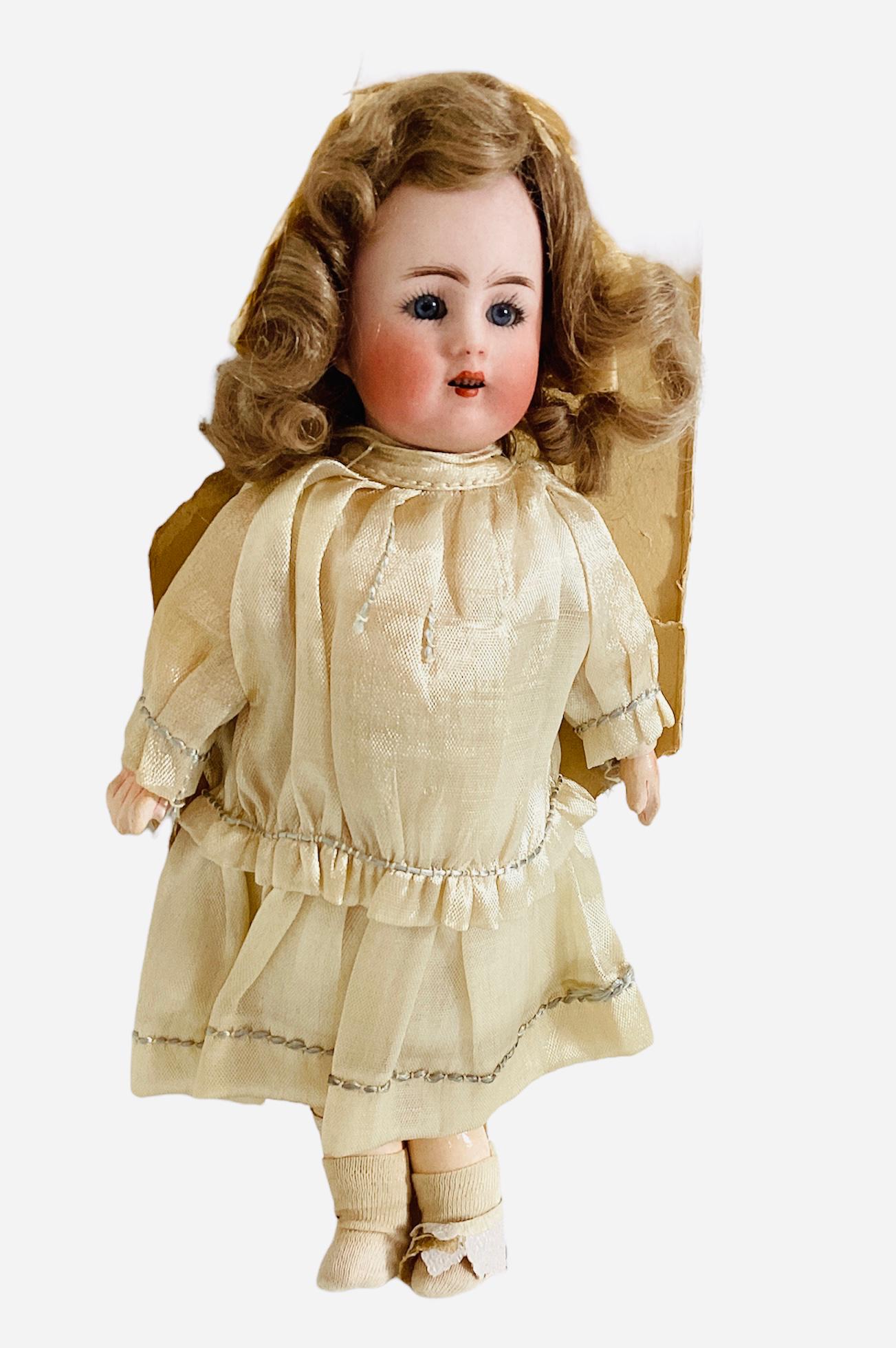Carl Hartmann Globe Baby. 8 1/2" bisque socket head doll with mohair wig, glass sleep eyes, open: Carl Hartmann Globe Baby. 8 1/2" bisque socket head doll with mohair wig, glass sleep eyes, open mouth with teeth, on jointed composition body. All original and attached to a portion of her cardboard,