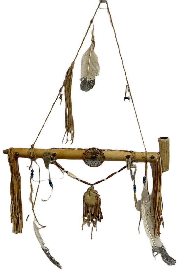Native American style peace pipe with chamber made of antler and stem made of wood wrapped in: Native American style peace pipe with chamber made of antler and stem made of wood wrapped in leather, with accents of beads, flint points, metal studs, feathers, leather fringe and hanger, 18.25"w.