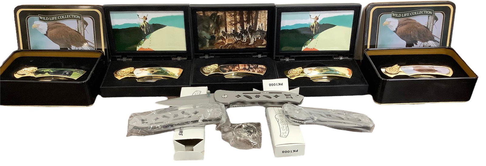 Lot of 5 stainless steel pocket knives in decorative boxes, 7"L when open, and decorated with Native: Lot of 5 stainless steel pocket knives in decorative boxes, 7"L when open, and decorated with Native American scenes/symbols, 3 stainless steel switch knives, 8"L, and a kokopelli keychain.