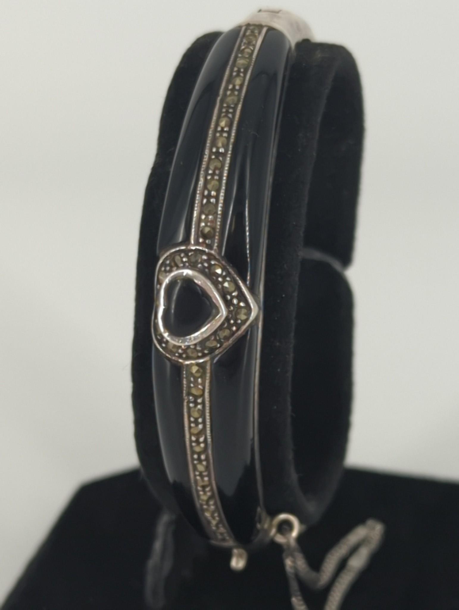 Sterling Silver Bracelet With Marcasite Stones & Black Enamel Inlay: Sterling Silver Bracelet With Marcasite Stones & Black Enamel Inlay Hinged design with an inner diameter of (2.2")featuring a heart shaped motif in the center, stamped and tested with a safety chain (